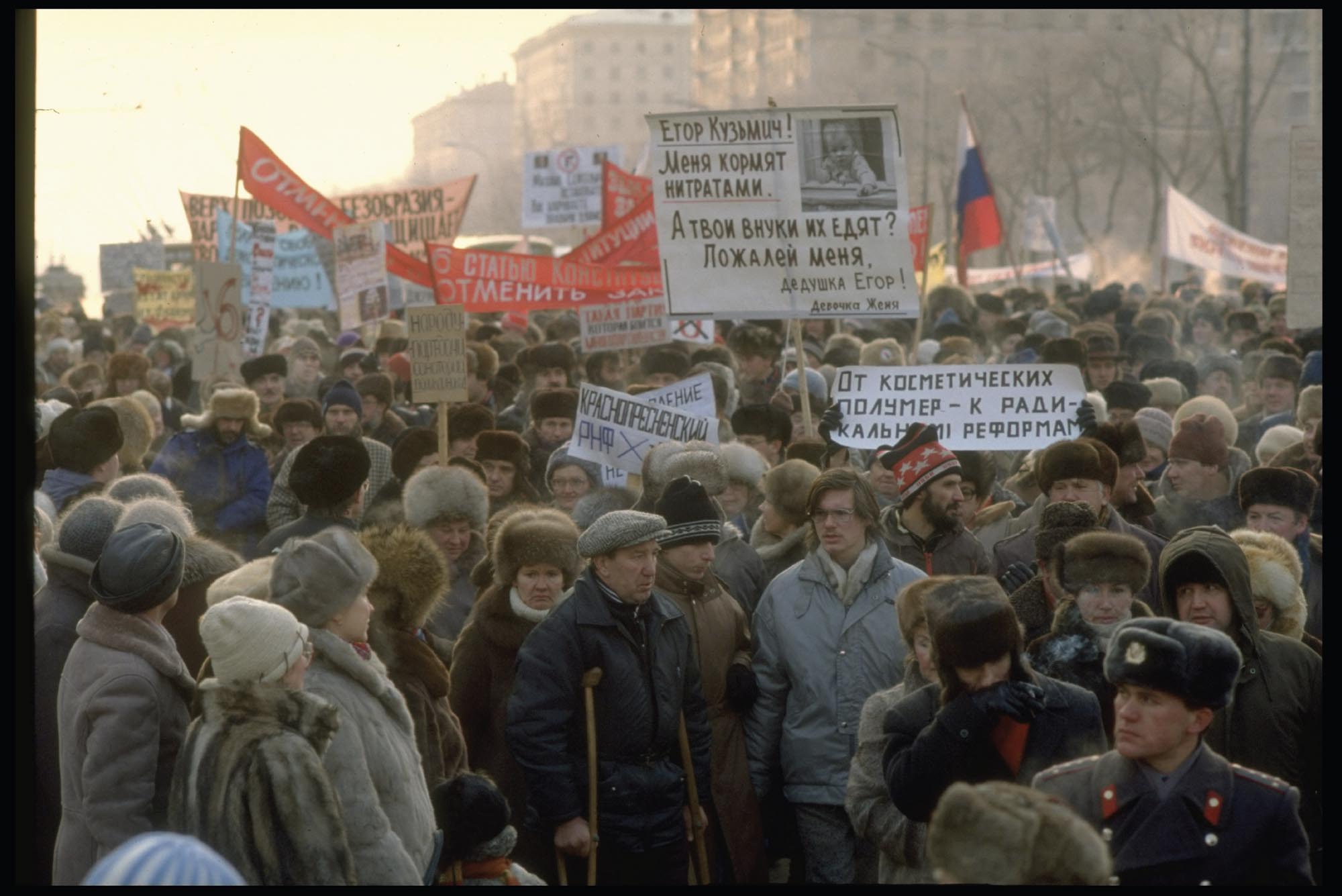 Photo of protestors lined up around the corner of a city block holding signs that call for independence from the Soviet Union.