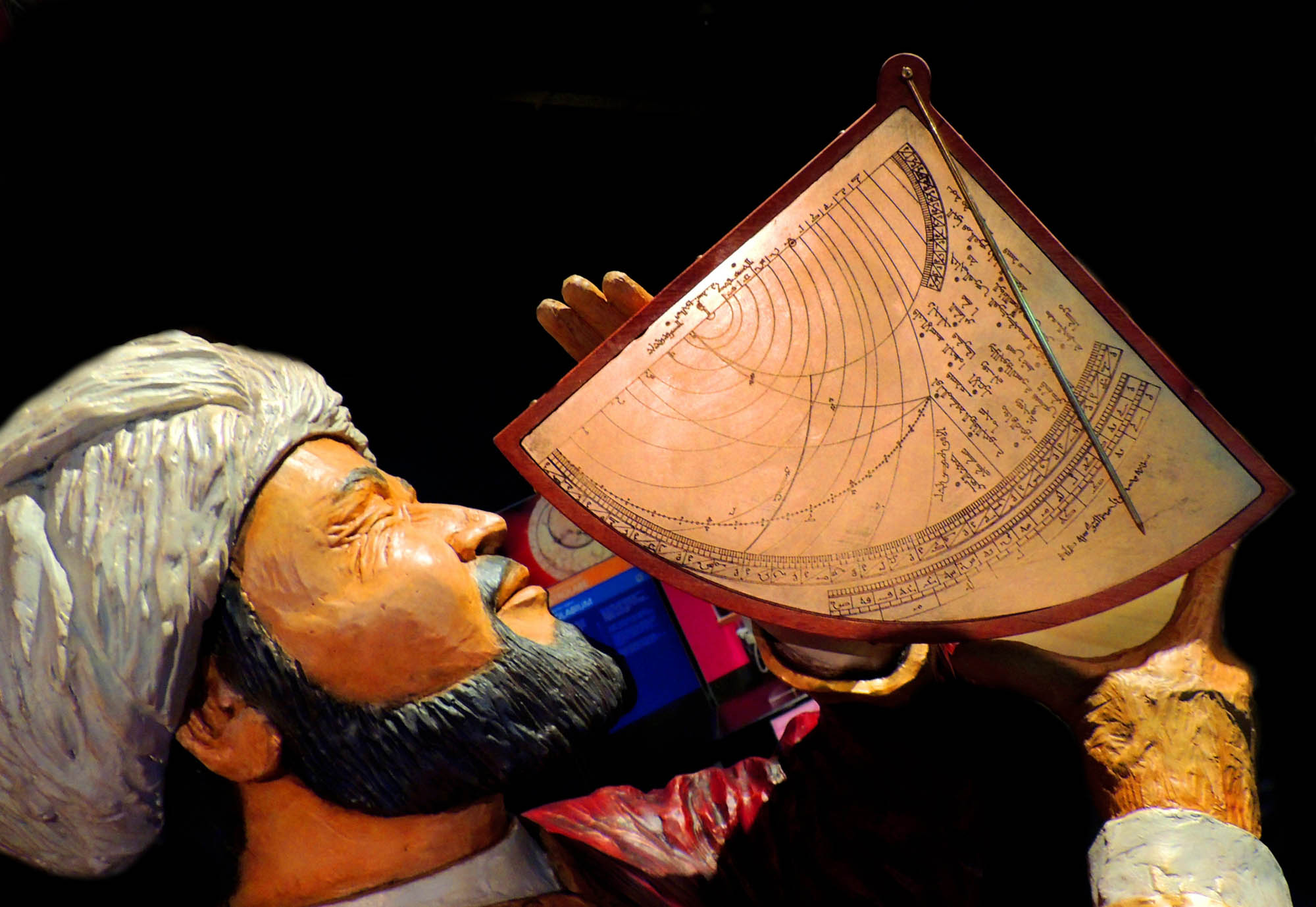 An astronomer holds a large triangular device to his eye and points to the sky.