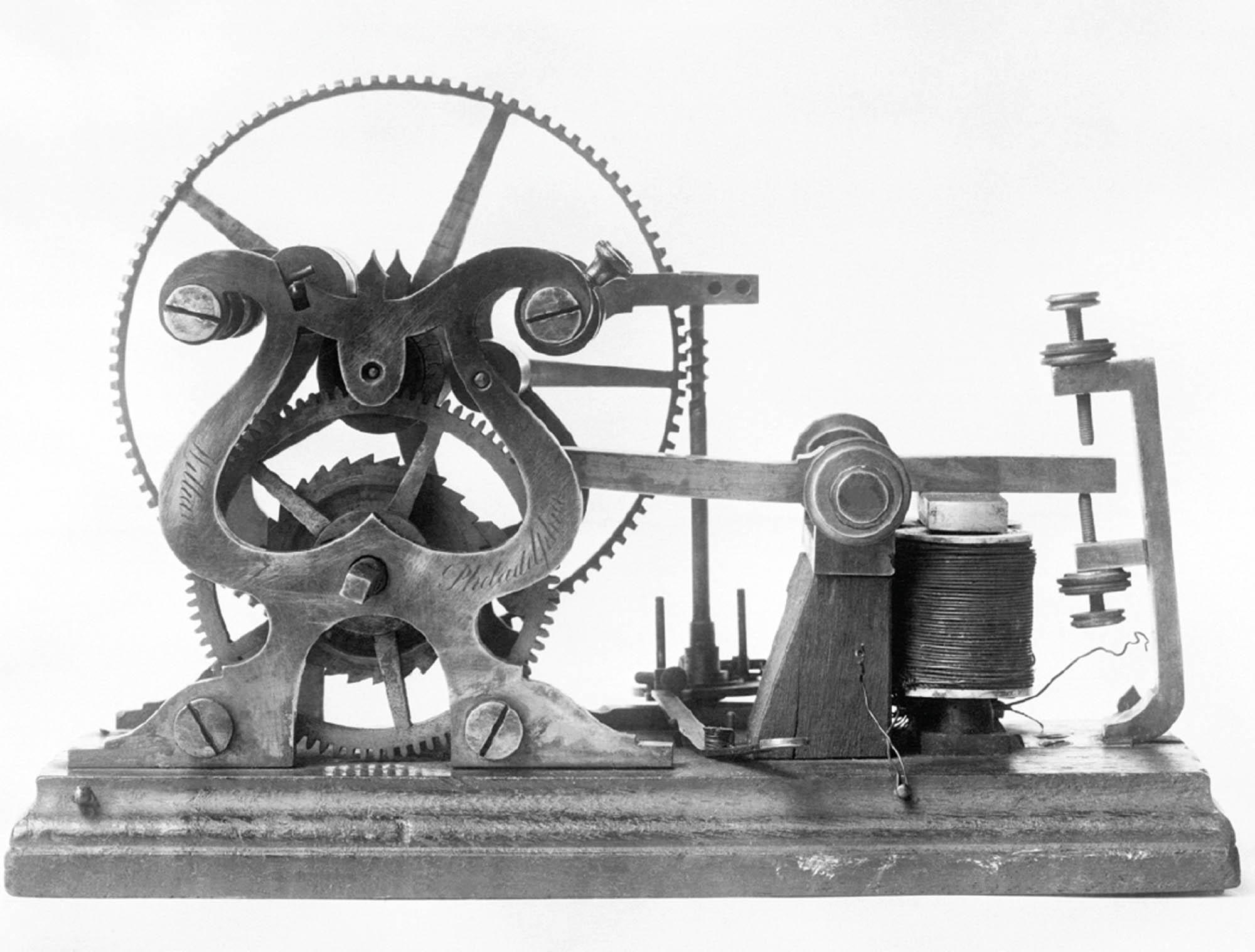 Picture of a telegraph, a machine with a round gear on the left connected to a pair of needles on the right.