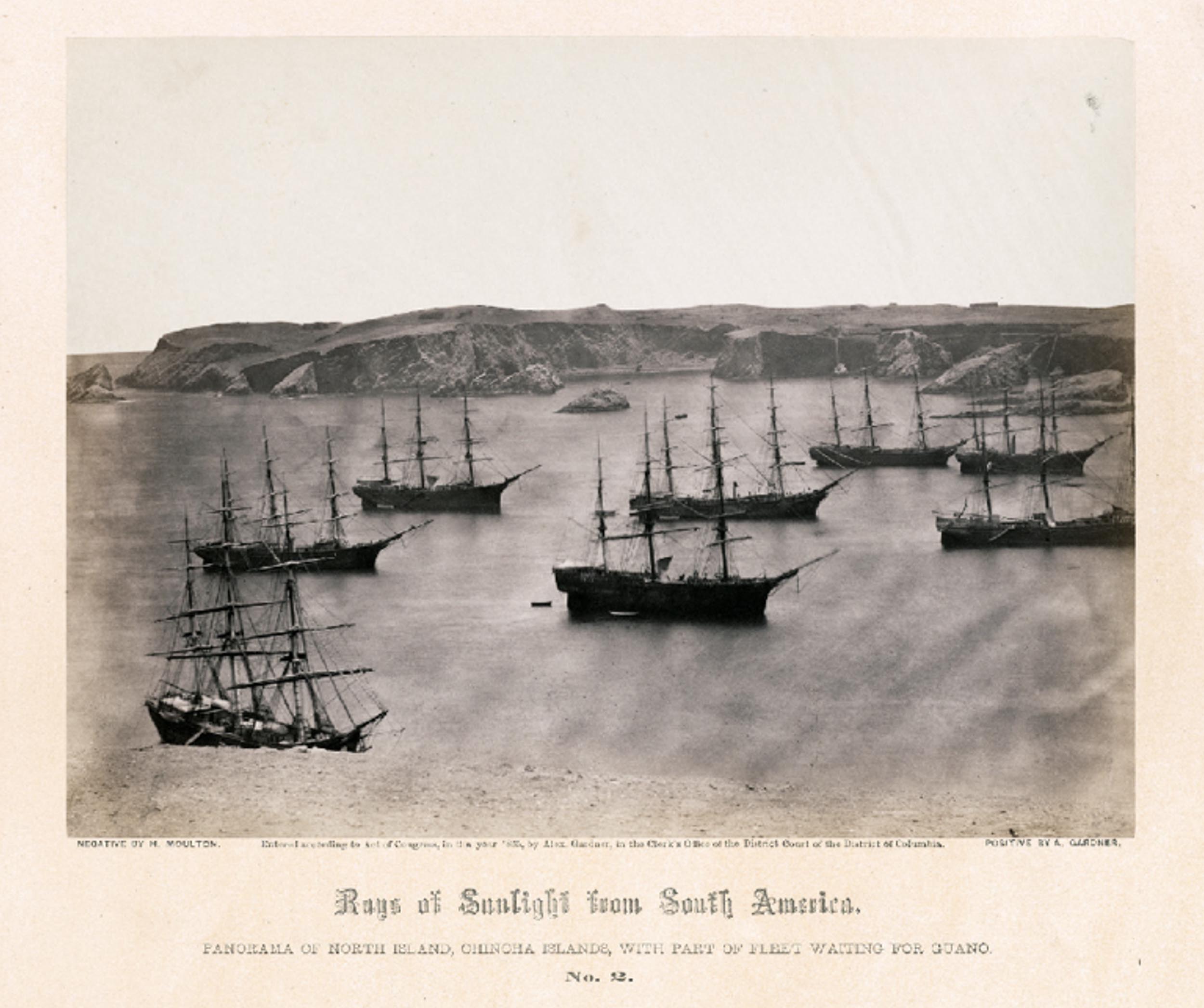 An image from the series, Guano mines in Peru: high-level view of a harbor filled with ships waiting to be loaded.