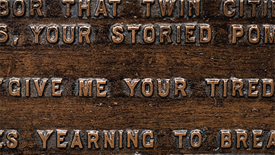 Detail of words from ‘The New Colossus’ poem by Emma Lazarus are engraved on a replica bronze plaque inside the Statue of Liberty Museum.