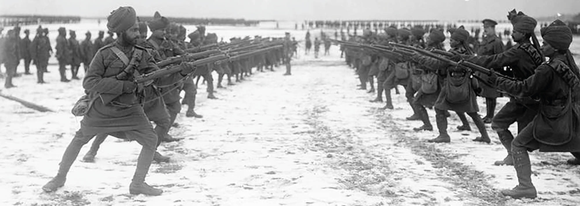 Picture of soldiers in the Indian army standing in two straight lines, facing each other, and aiming their guns.