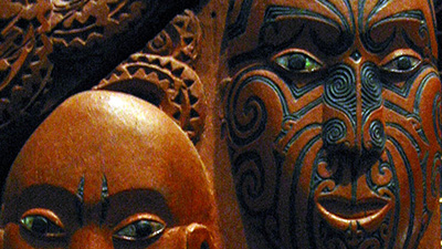 Wooden carvings featuring two Māori gods embracing.