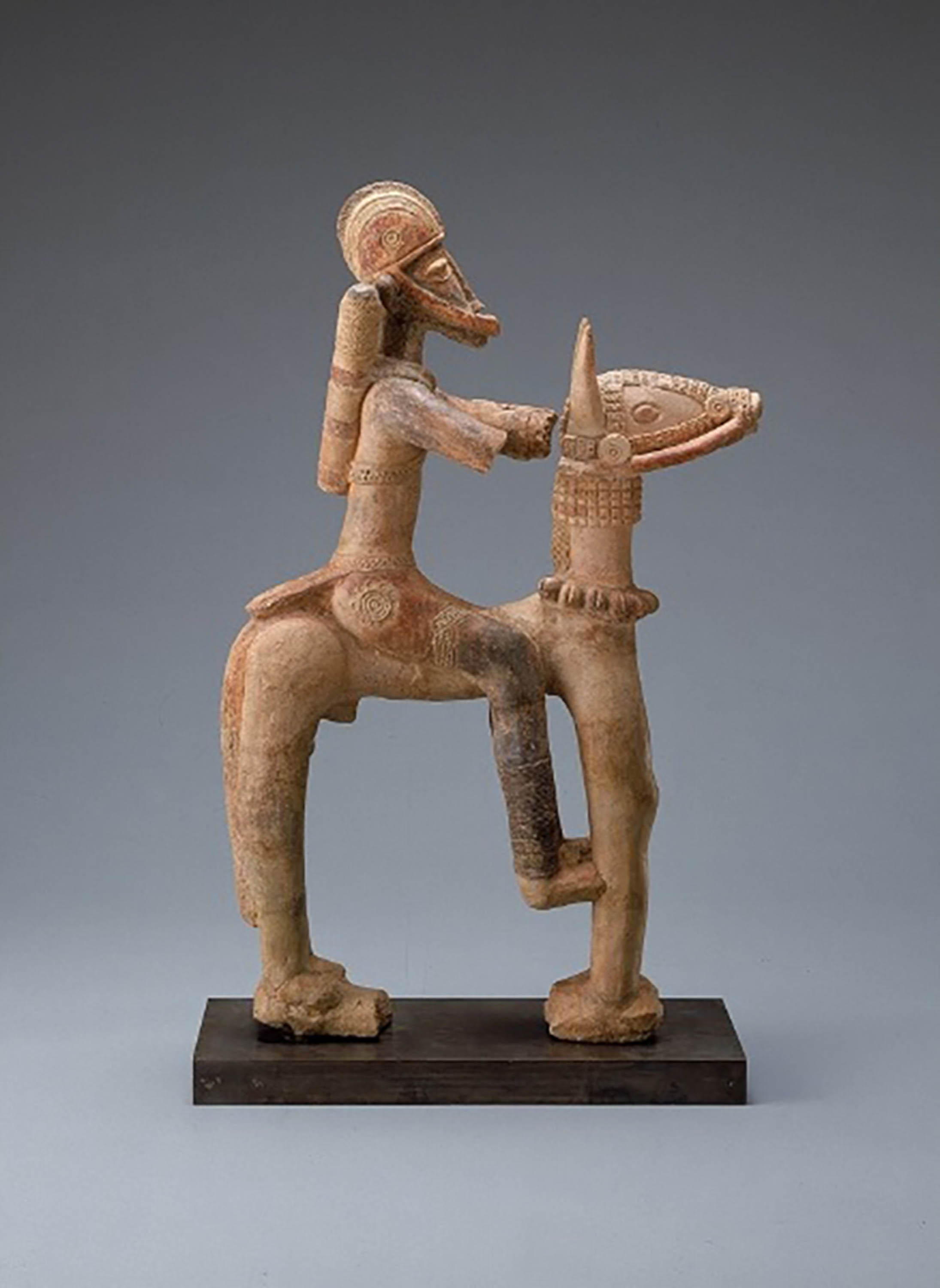 Terracotta statue of a rider in traditional armor on horseback, created by people in medieval West Africa.