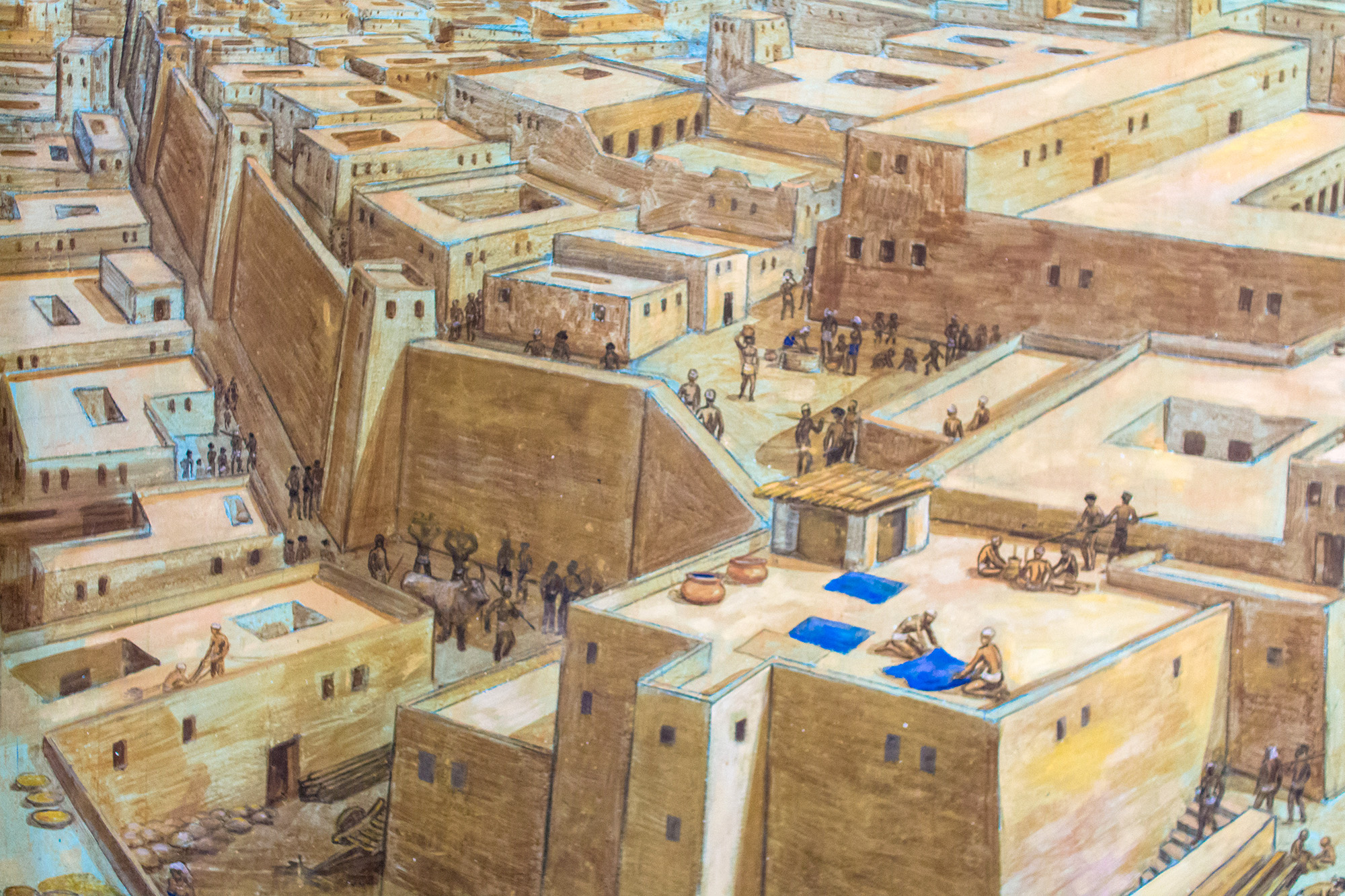 Illustration of what a city block with buildings in Mohenjo-Daro would have looked like circa 2500 BCE. Stone buildings are surrounded by tall walls while citizens walk through the streets and rest on rooftops.
