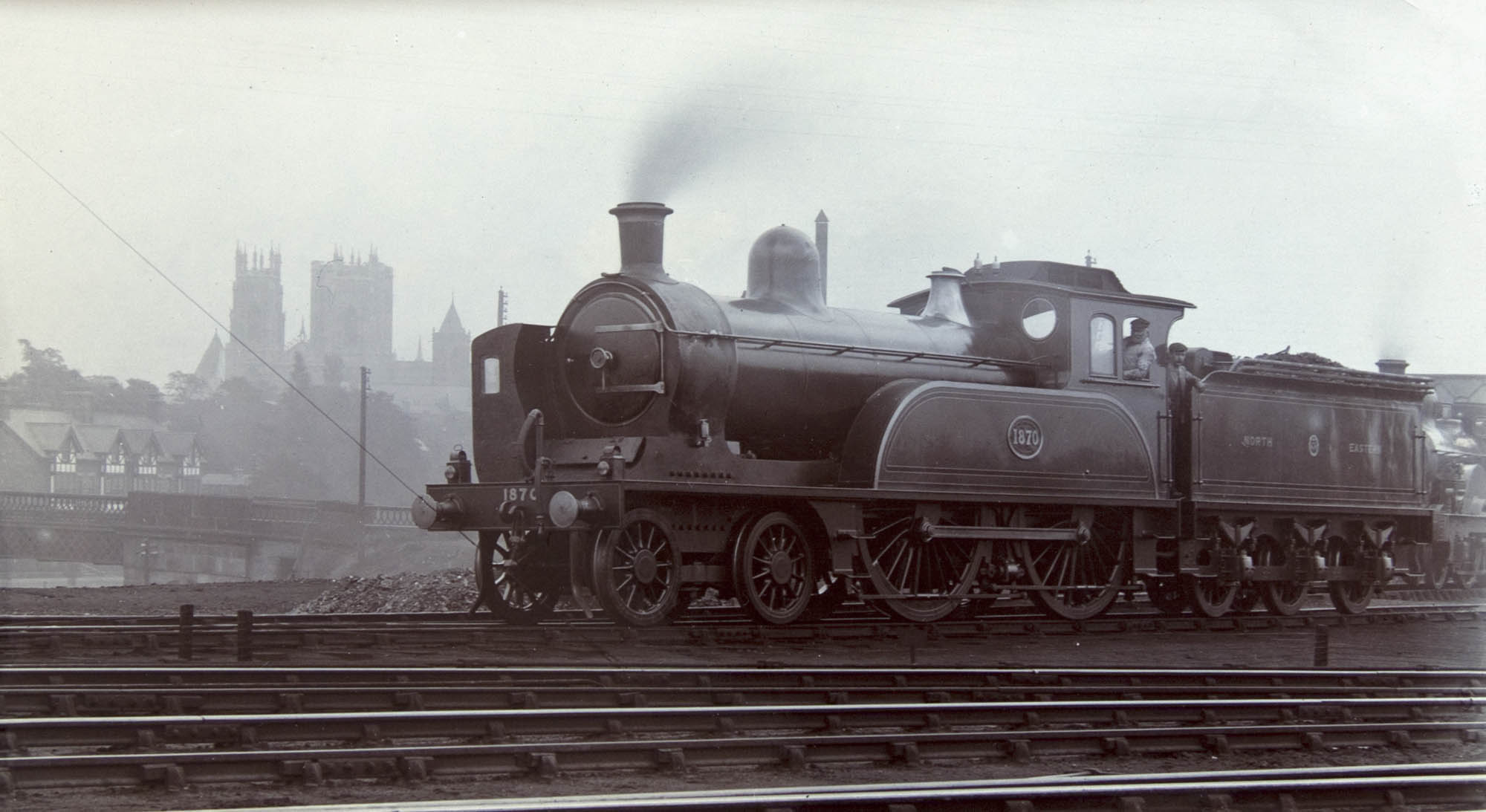 A steam train on railroad tracks.