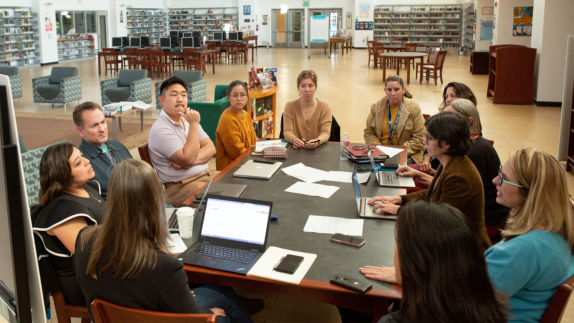 A group of teachers sitting around an office desk comparing notes.