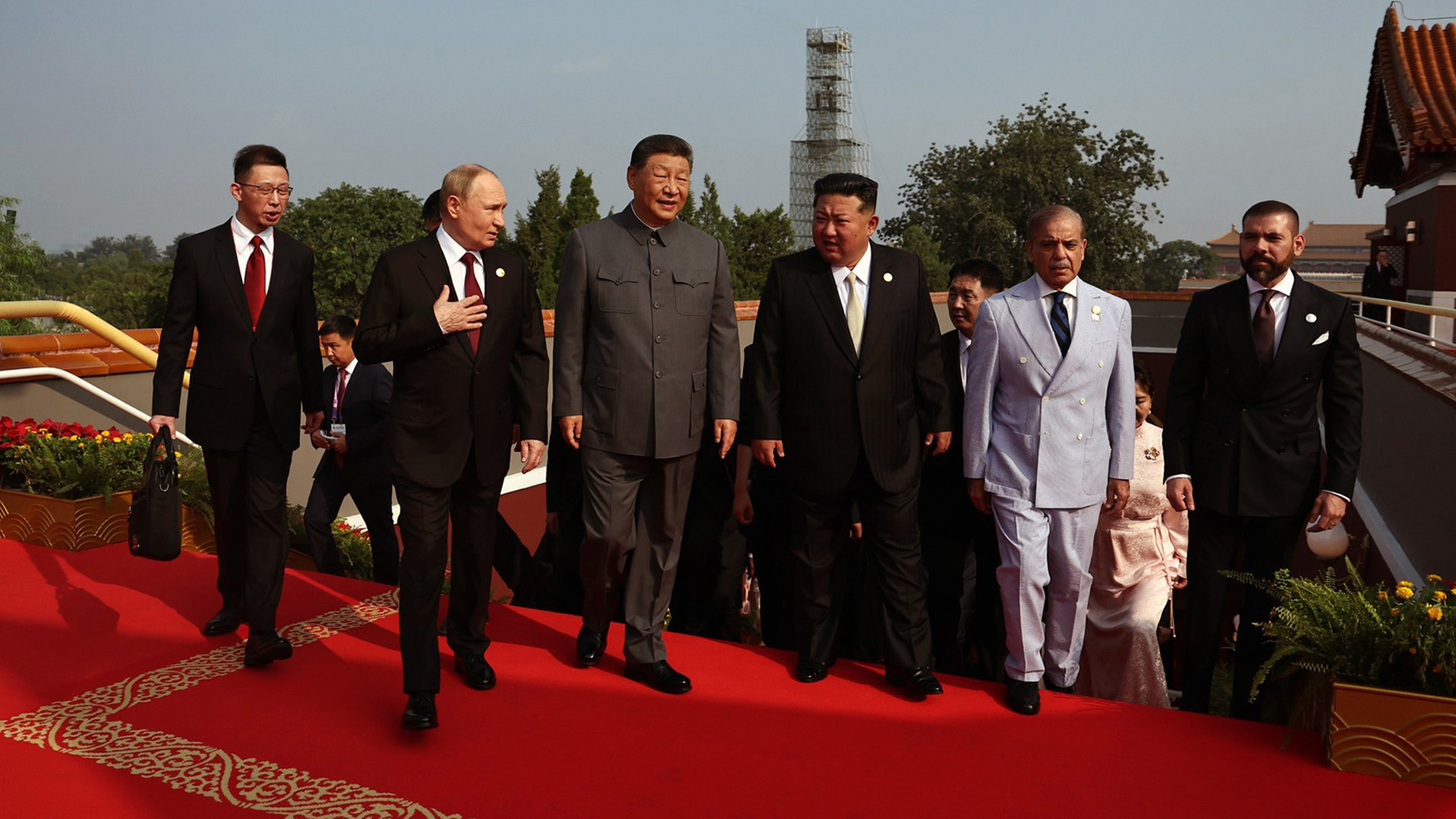 A photo of Vladimir Putin, Xi Jinping, and Kim Jong Un on a red carpet.