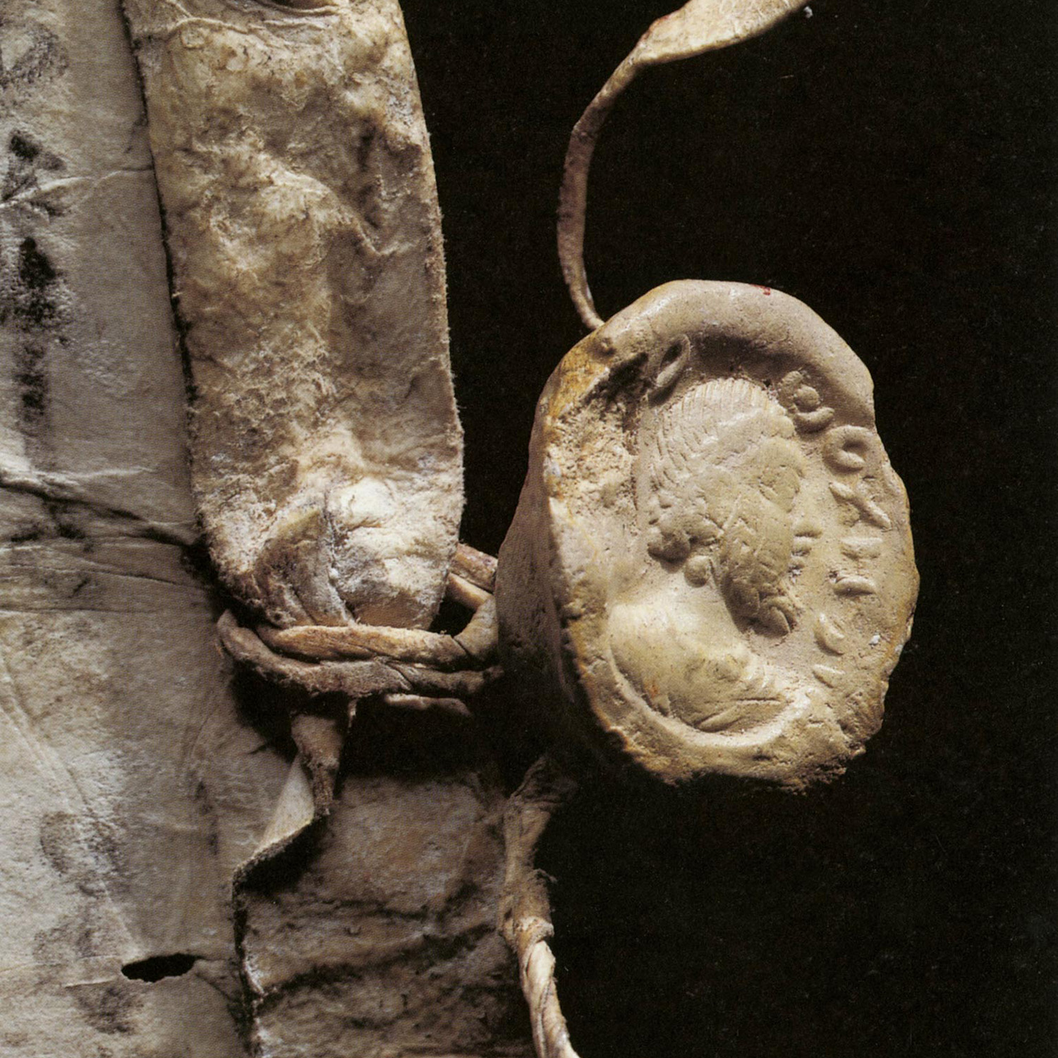 An antique seal bearing a man's face in profile.