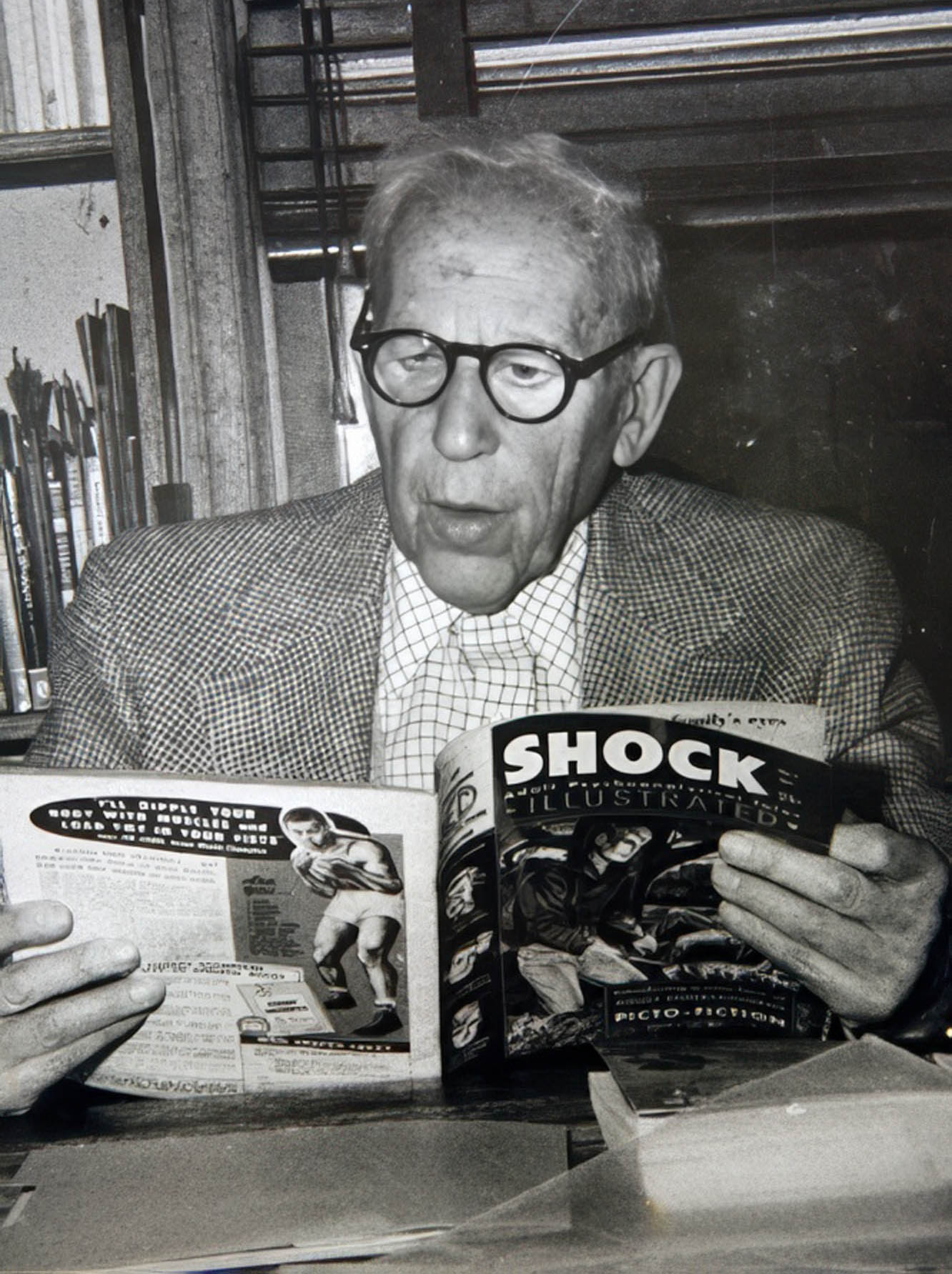 An elderly man reads a copy of the comic Shock.