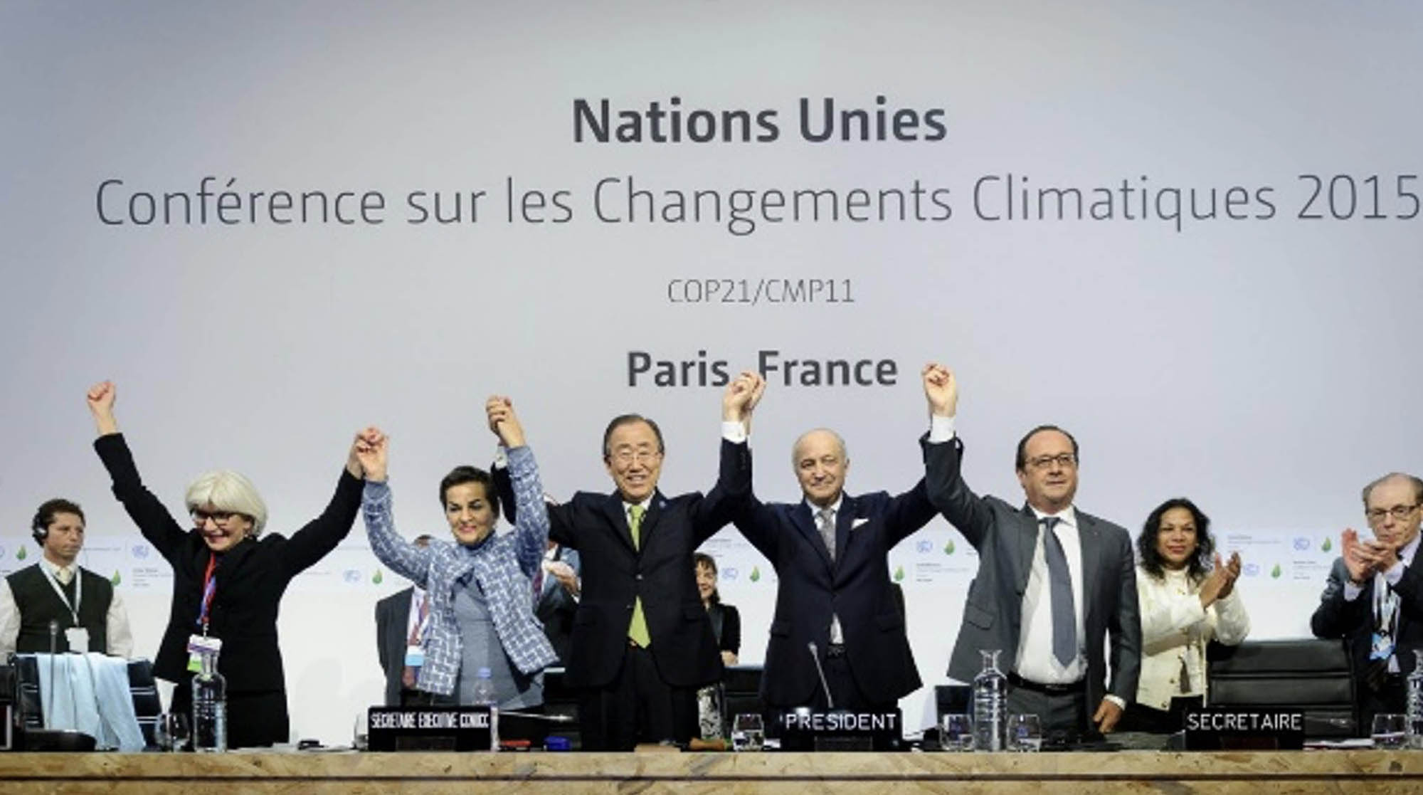 World leaders and representatives with hands joined in the air after signing the Paris Agreement at the 2015 United Nations Climate Change Conference (COP21/CMP11).