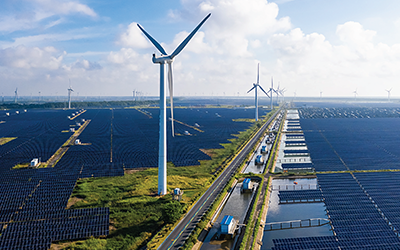 Solar power stations in plain areas, wind turbines in the distance. Yancheng City, Jiangsu Province, China.