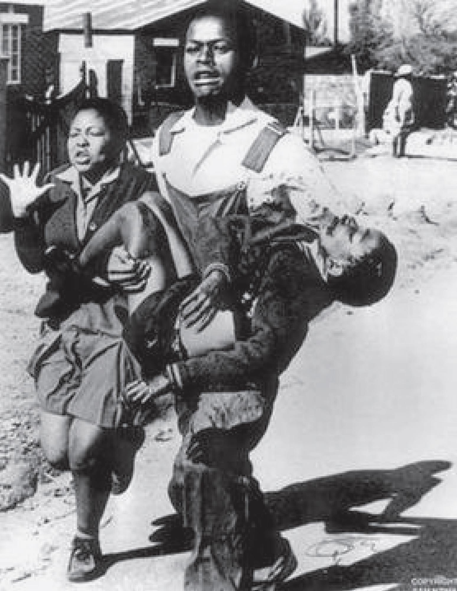 Photo of Mbuyisa Makhubo running for help with an injured Hector Pieterson in his arms after he was shot by the South African police. Pieterson’s sister runs alongside them.
