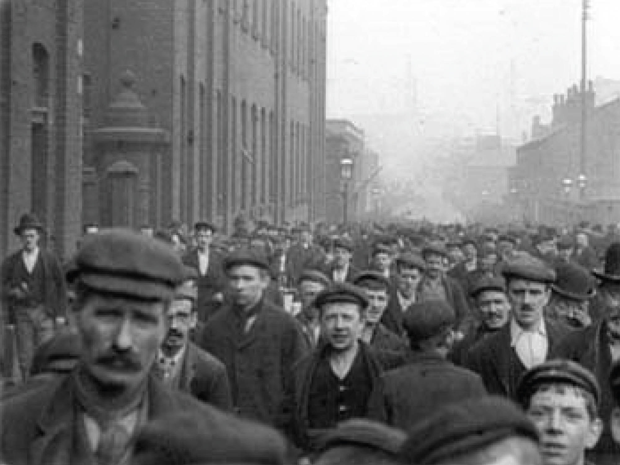 Photo of tired looking factory workers leaving work at the end of the day.