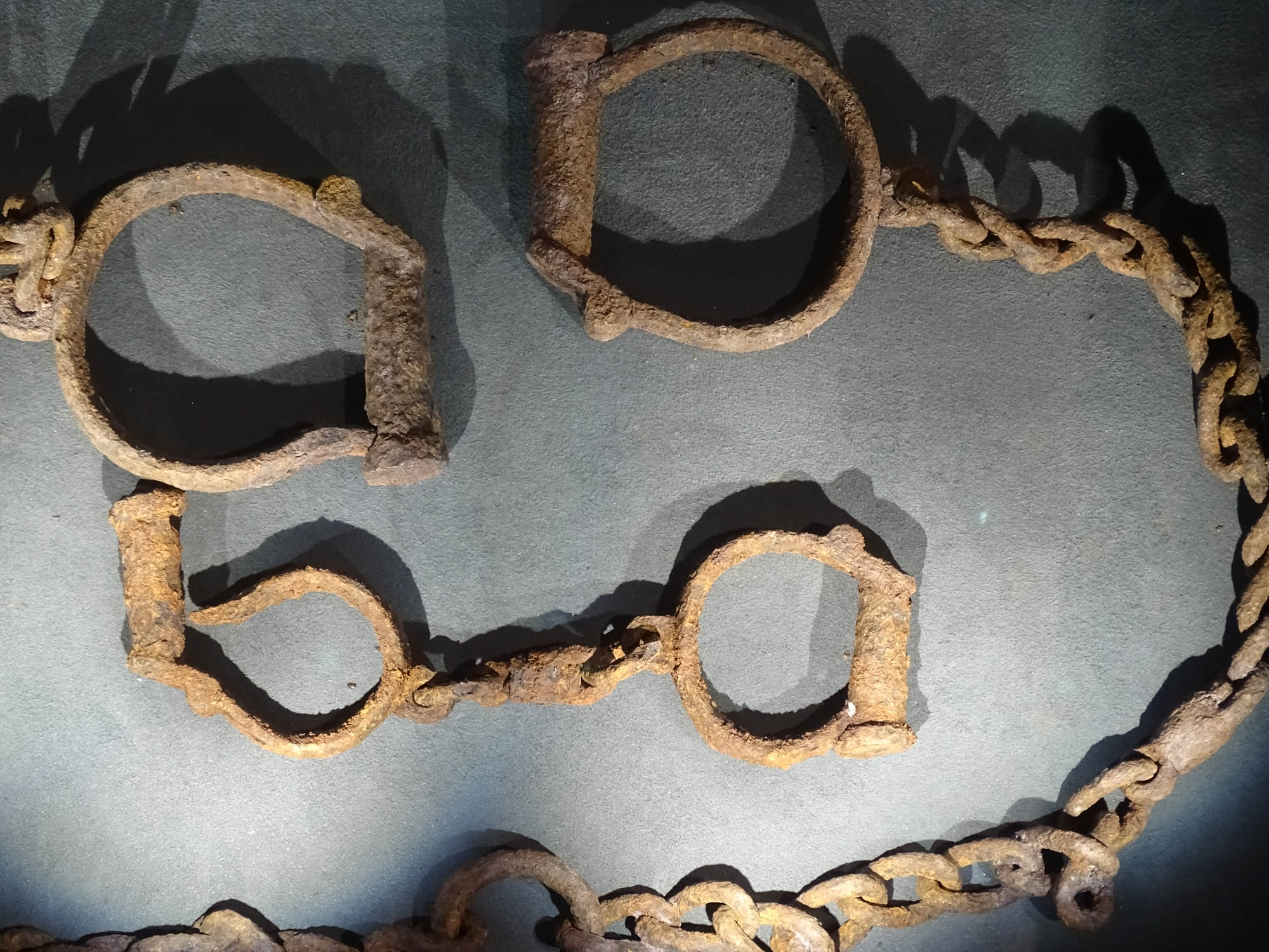 Photo of rusted, metal shackles used to cuff the wrists and ankles of slaves.