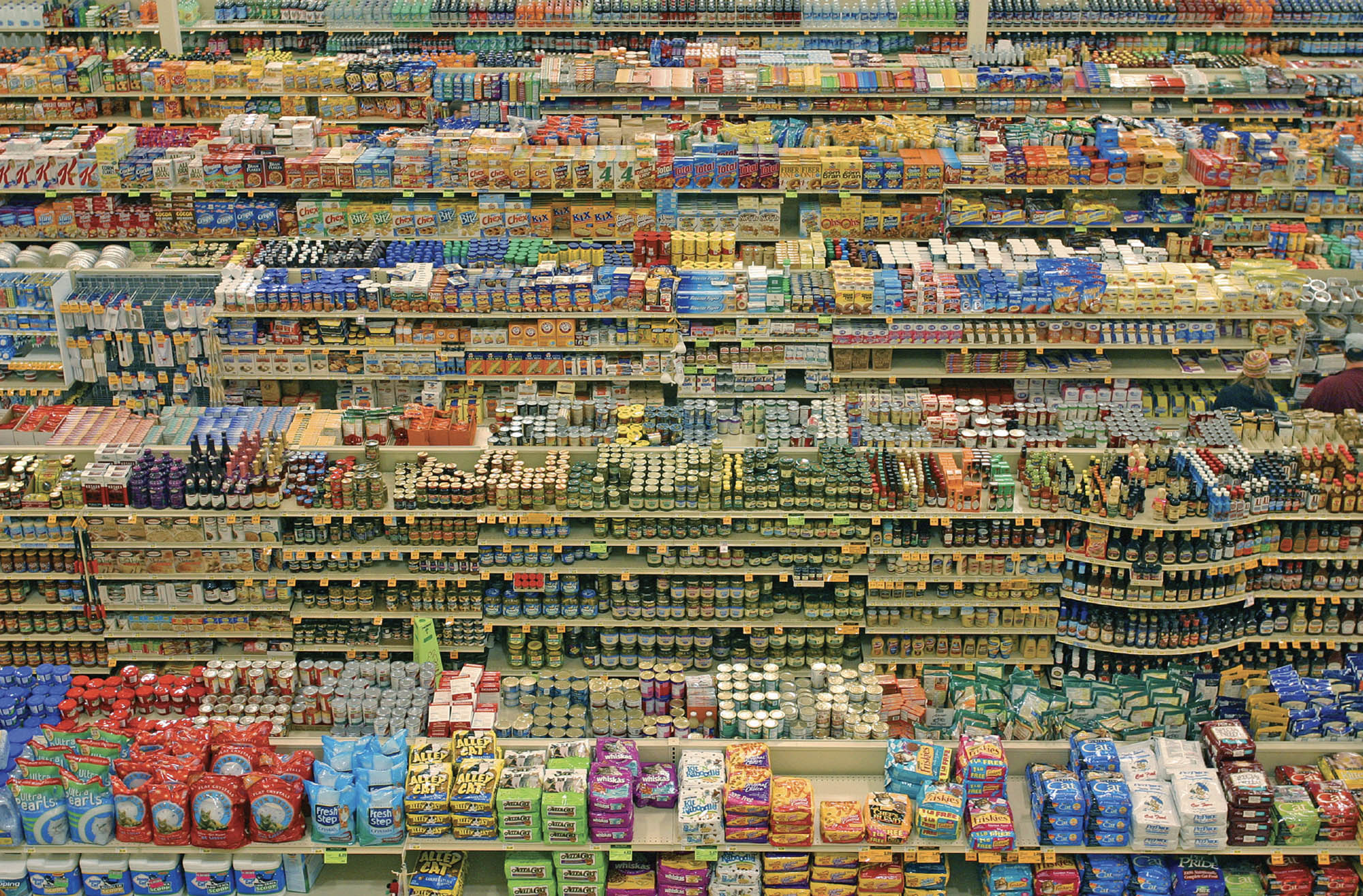 Photo of grocery store shelves packed full of jars, cans, drinks, and other boxed foods.