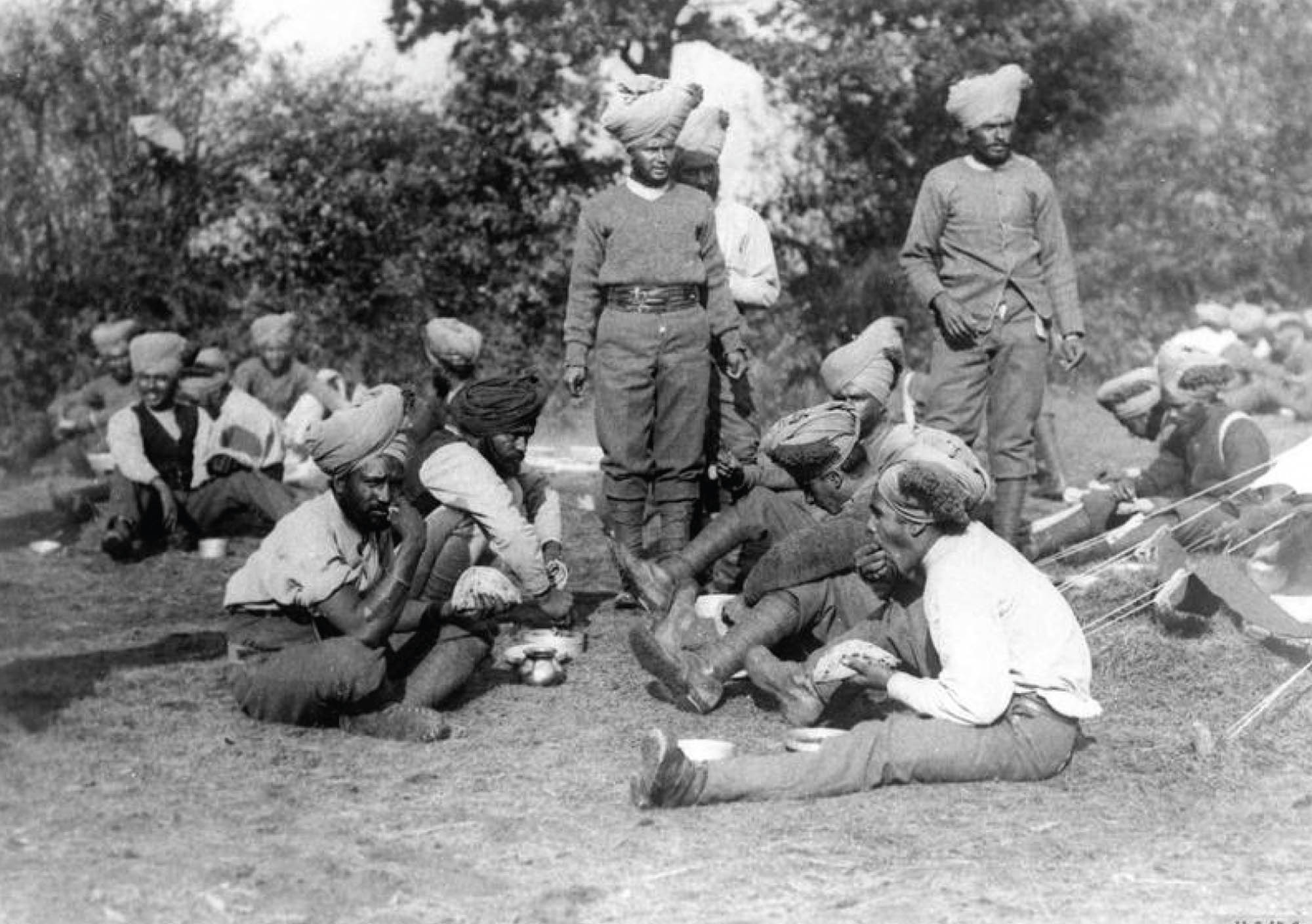 Photo of Indian soldiers sitting on the ground eating chapati.