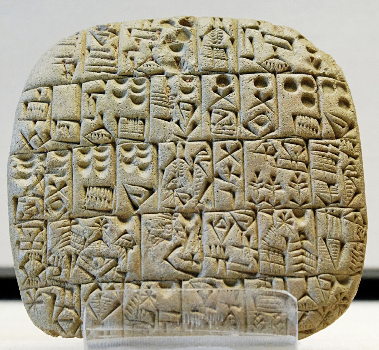 A rock carved into small rectangular sections. Each section is carved with a different collection of symbols