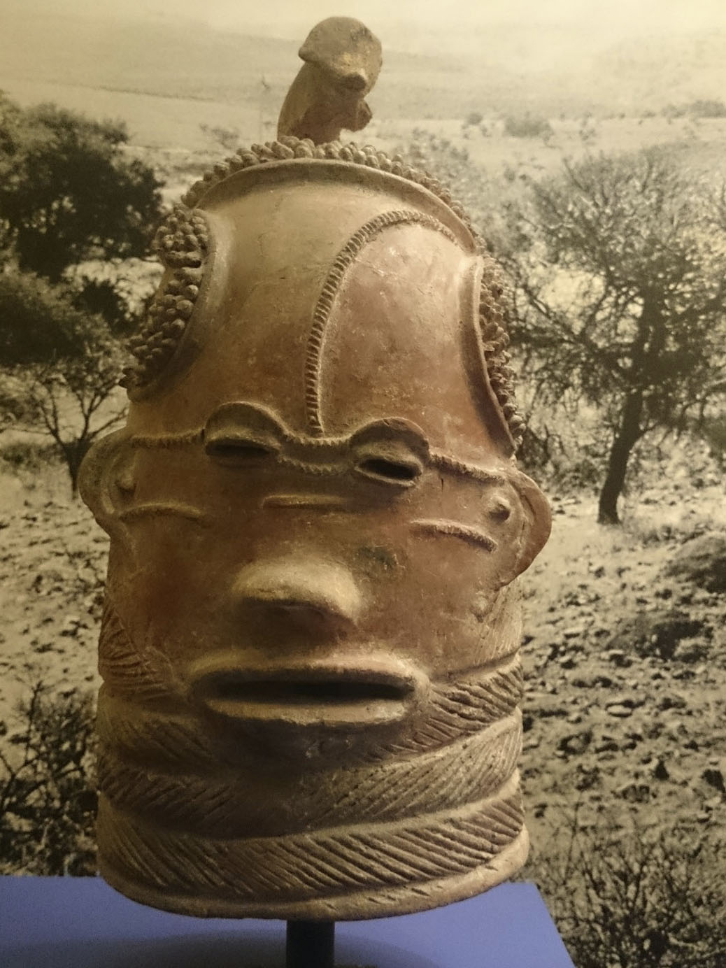 A sculpted artwork of the head of a figure, featuring elaborate carvings