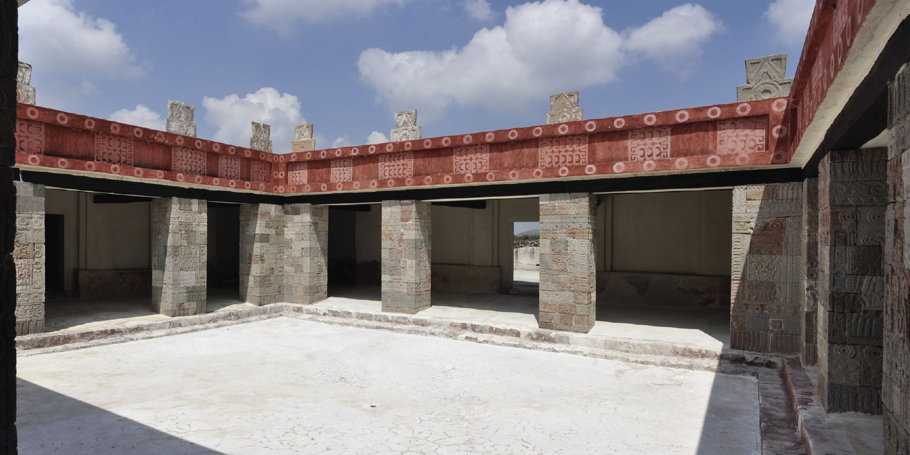 A photo of a courtyard that is surrounded by pillars made of carved stone.