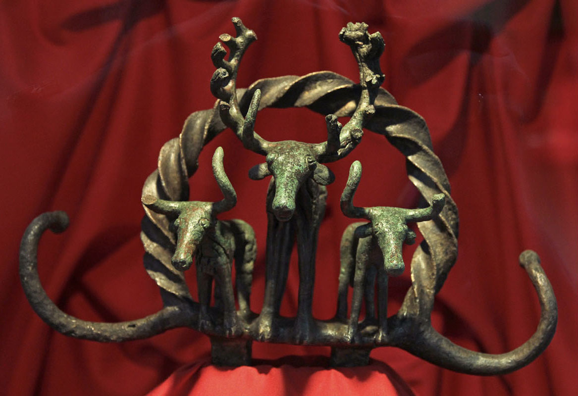 Bronze statue of three animals. All three of them have large, curving antlers; the animal in the center is the largest.