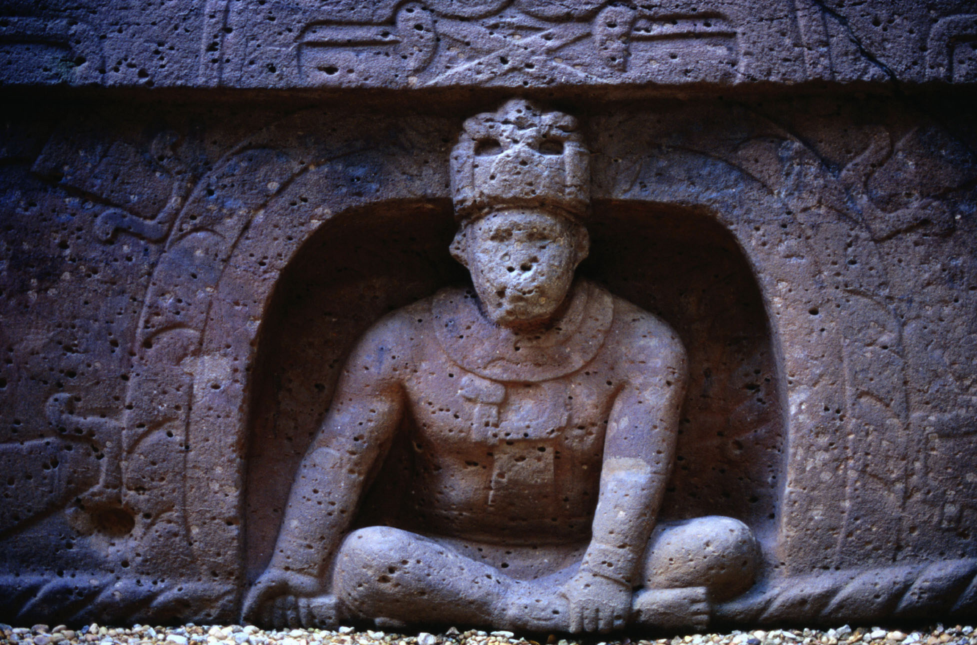 Detailed stone carving of a person sitting cross-legged in a dome