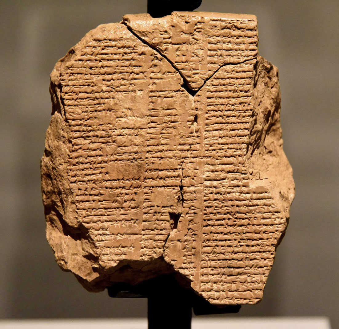 A photo of a slab of rock carved with text being shown in a museum