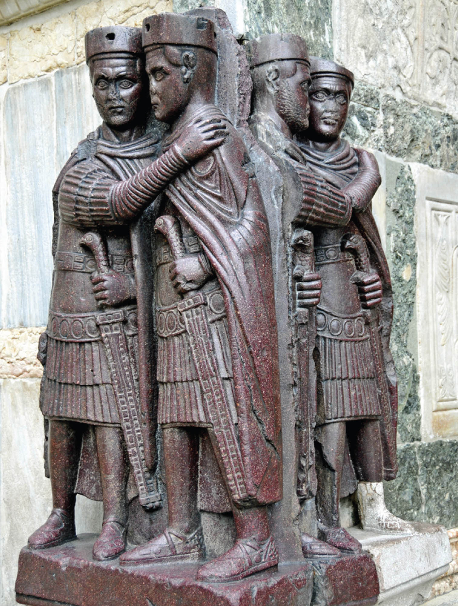 Photograph of two sets of statues. The statues depict one man with his arm around the other.