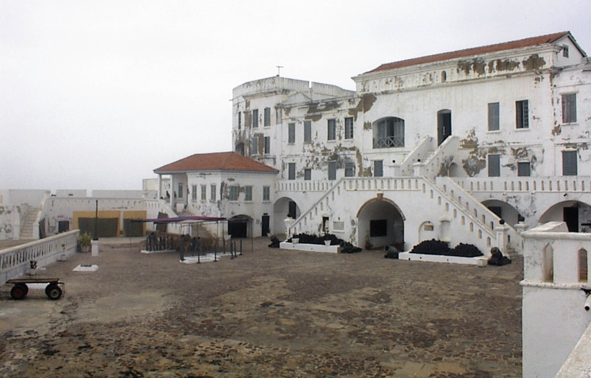 A worn down, white-painted building on the coast.