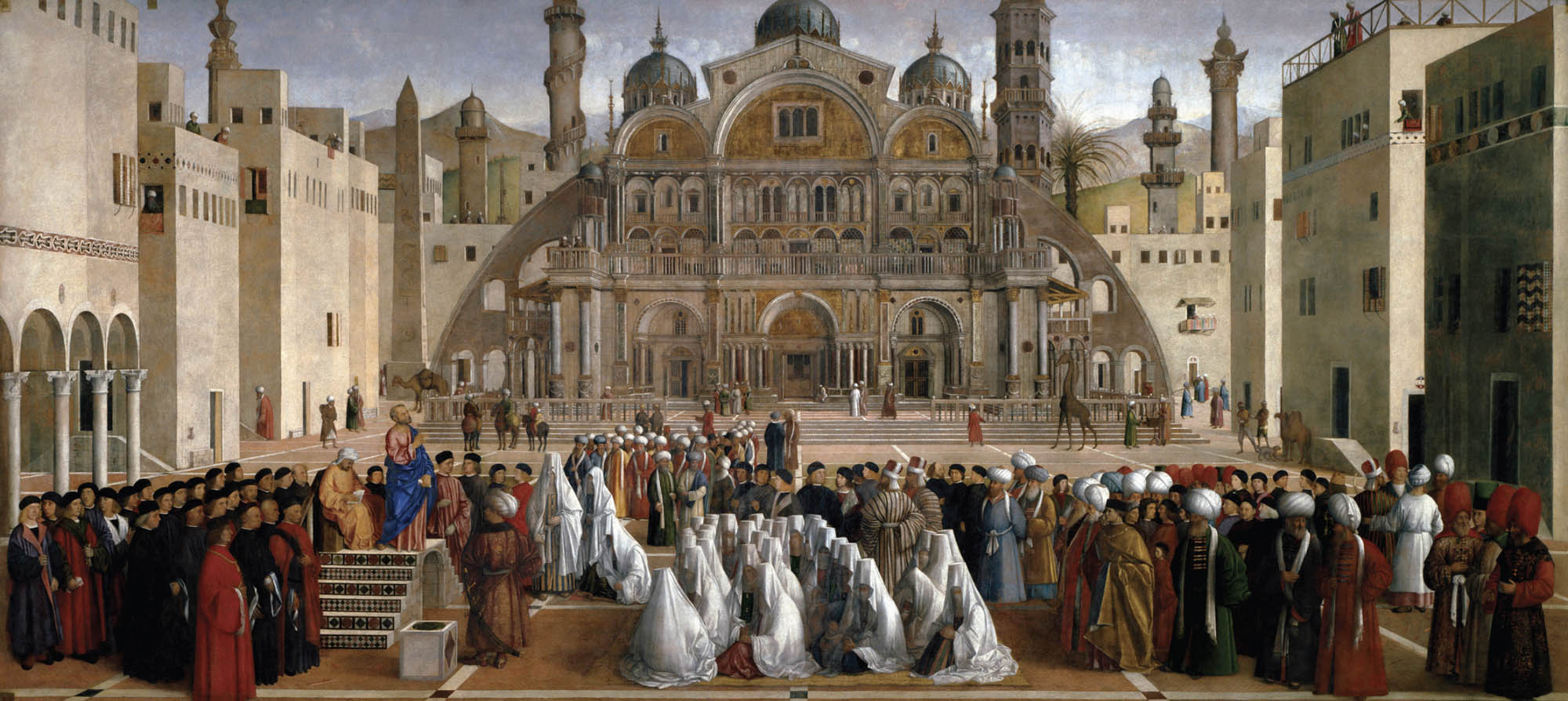 A large group of people dressed in various religious and cultural garb are gathered outside in a large courtyard listening to St. Mark preach from a slightly elevated small stage.