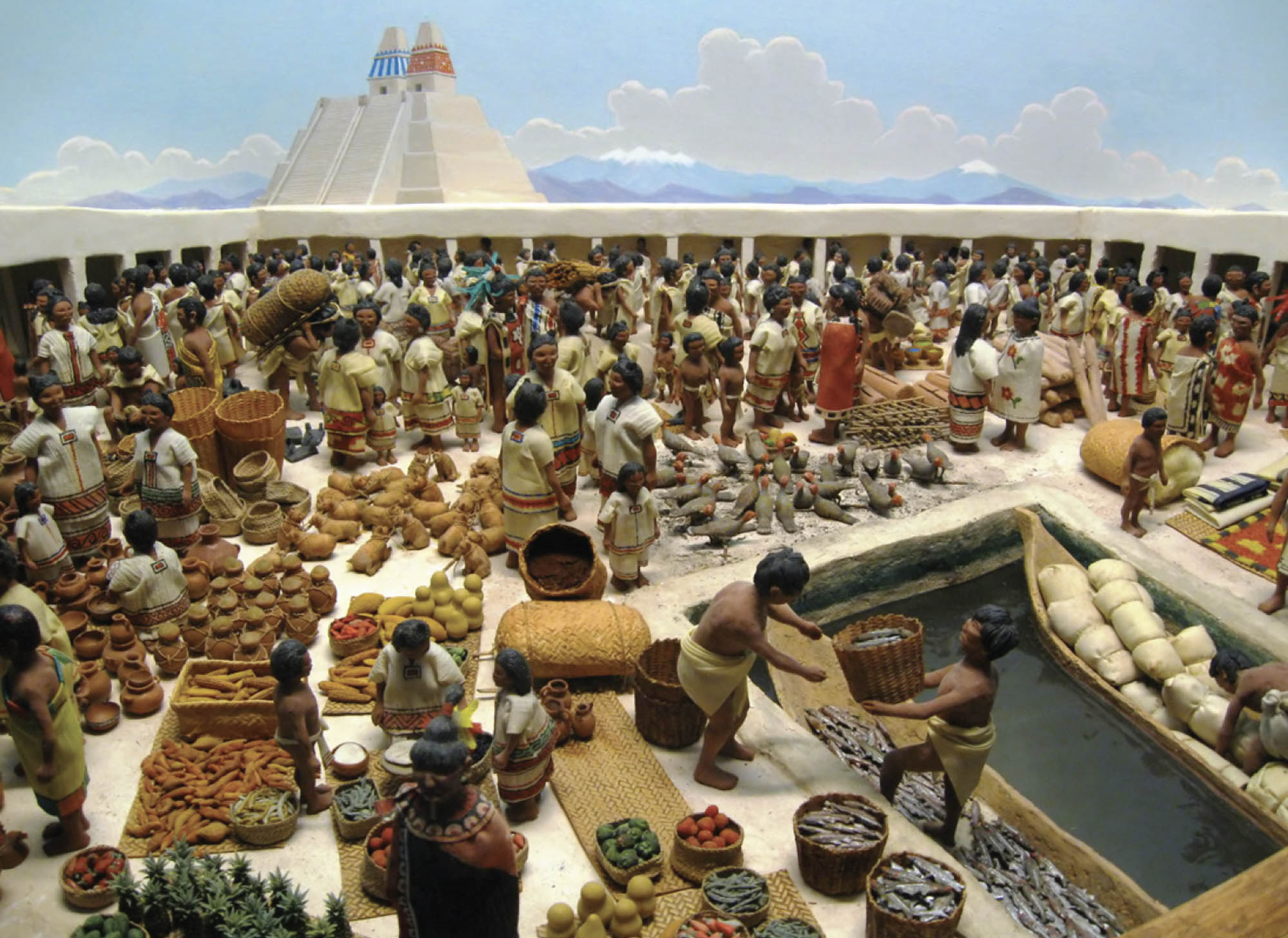 A model of a marketplace made out of clay. The marketplace is crowded with people trading goods like baskets, fish, vegetables, pottery, and textiles.