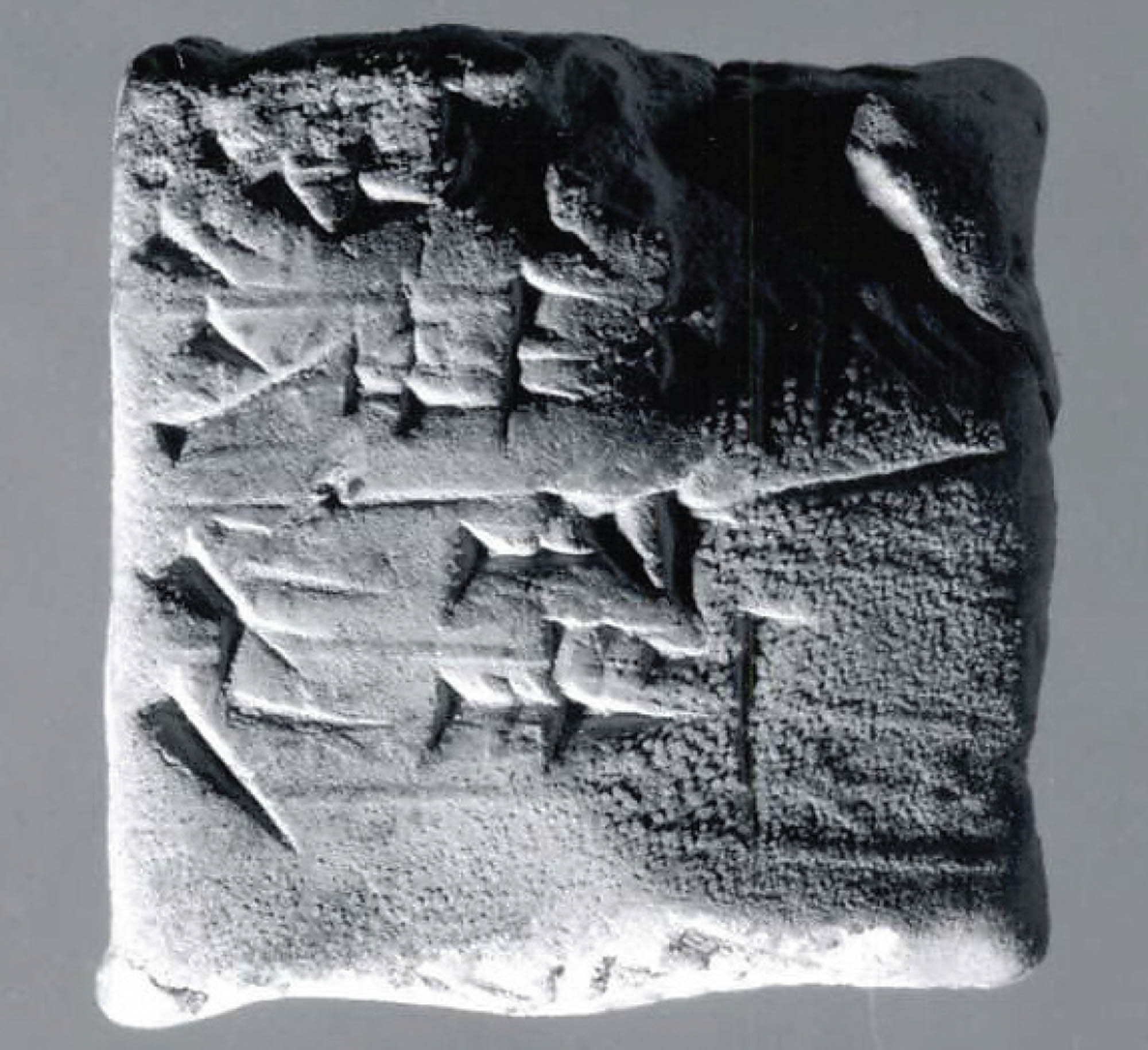 Square-shaped stone slab that has text carved into it.