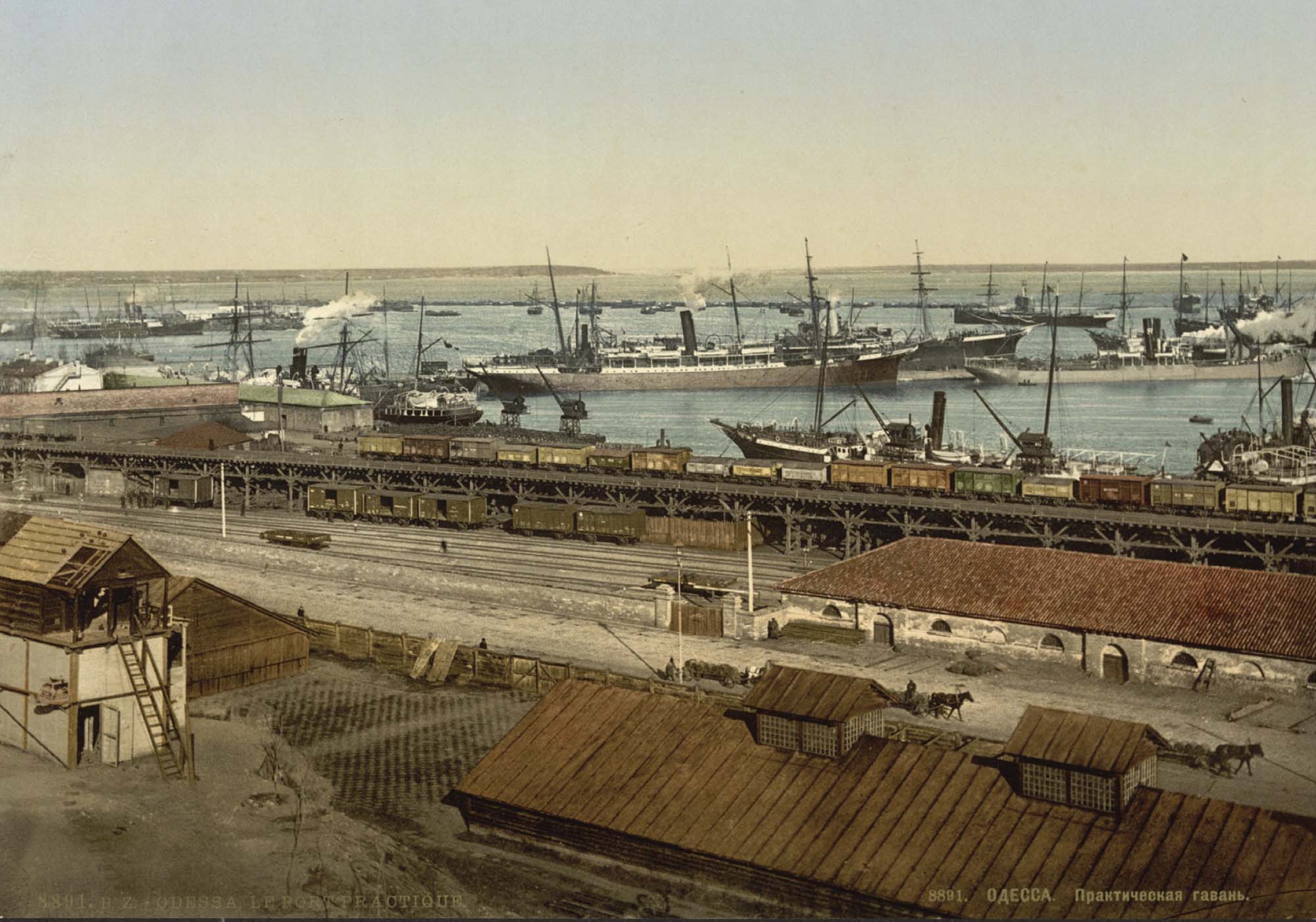 Painting of a busy port. Many large ships are nearby, and a long cargo train holds goods near the dock.  