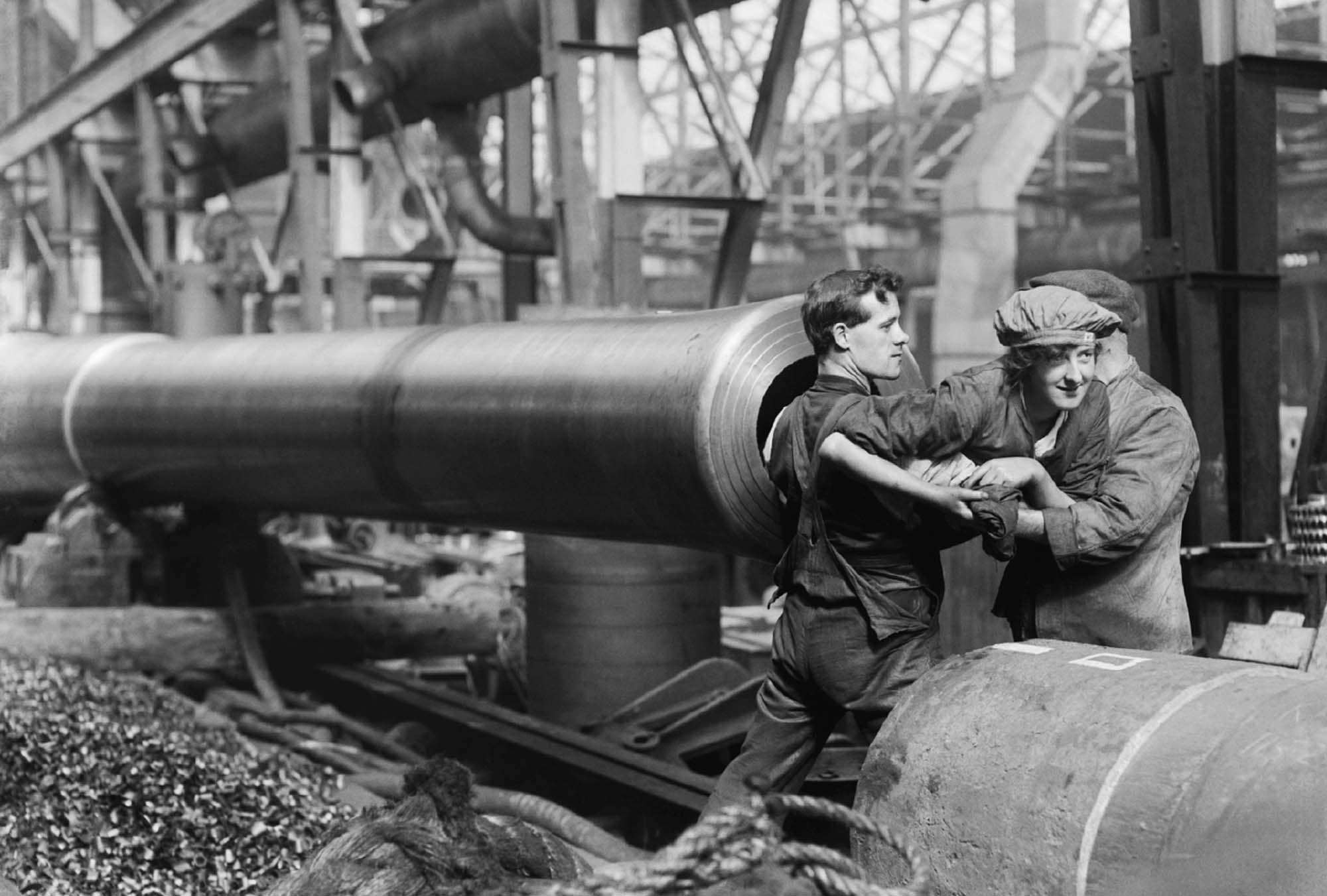 A photograph shows a woman being lifted into the inside of canon by two male soldiers.