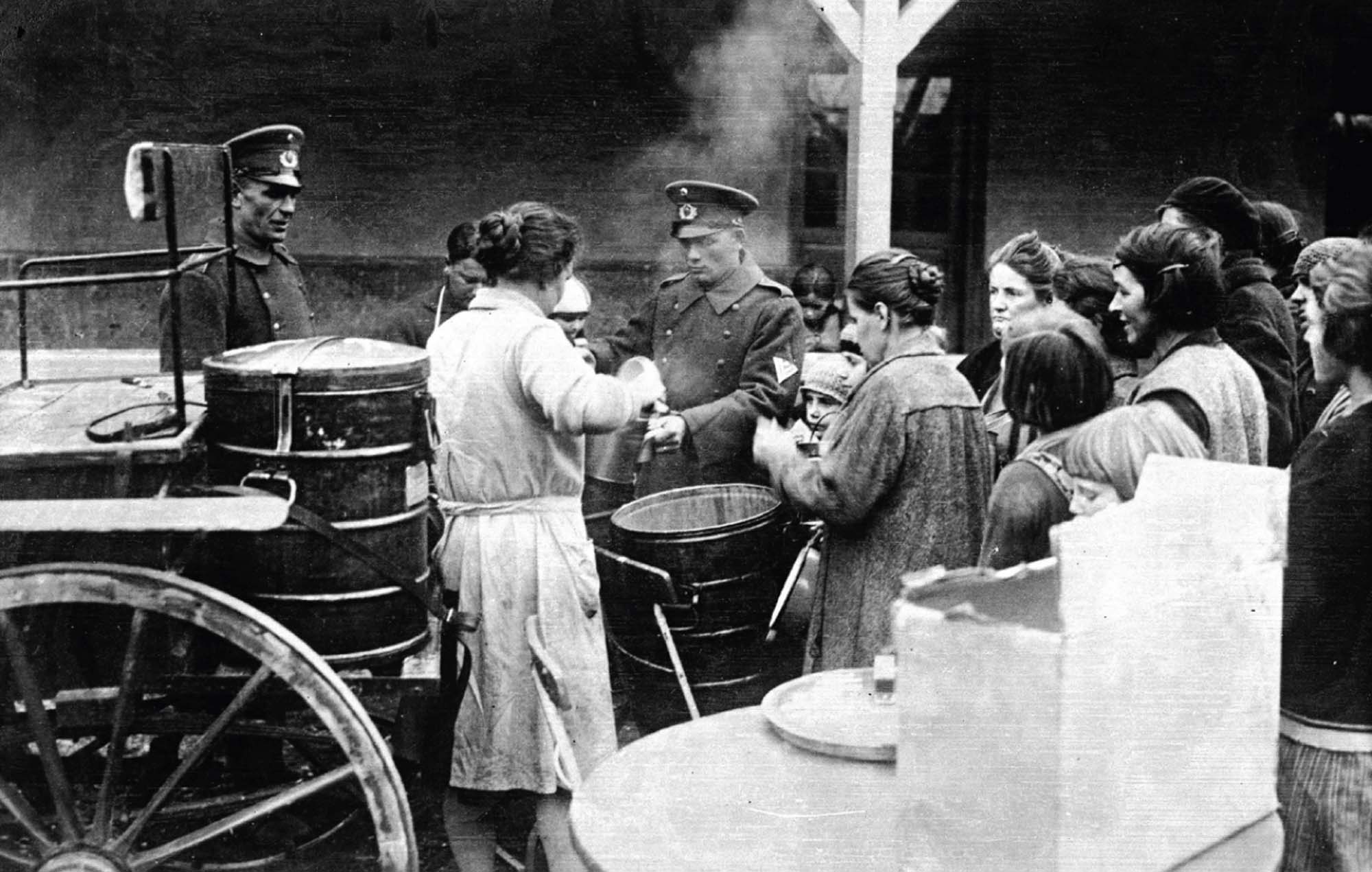 Soldiers feed a crowd of unemployed from a mobile canteen.