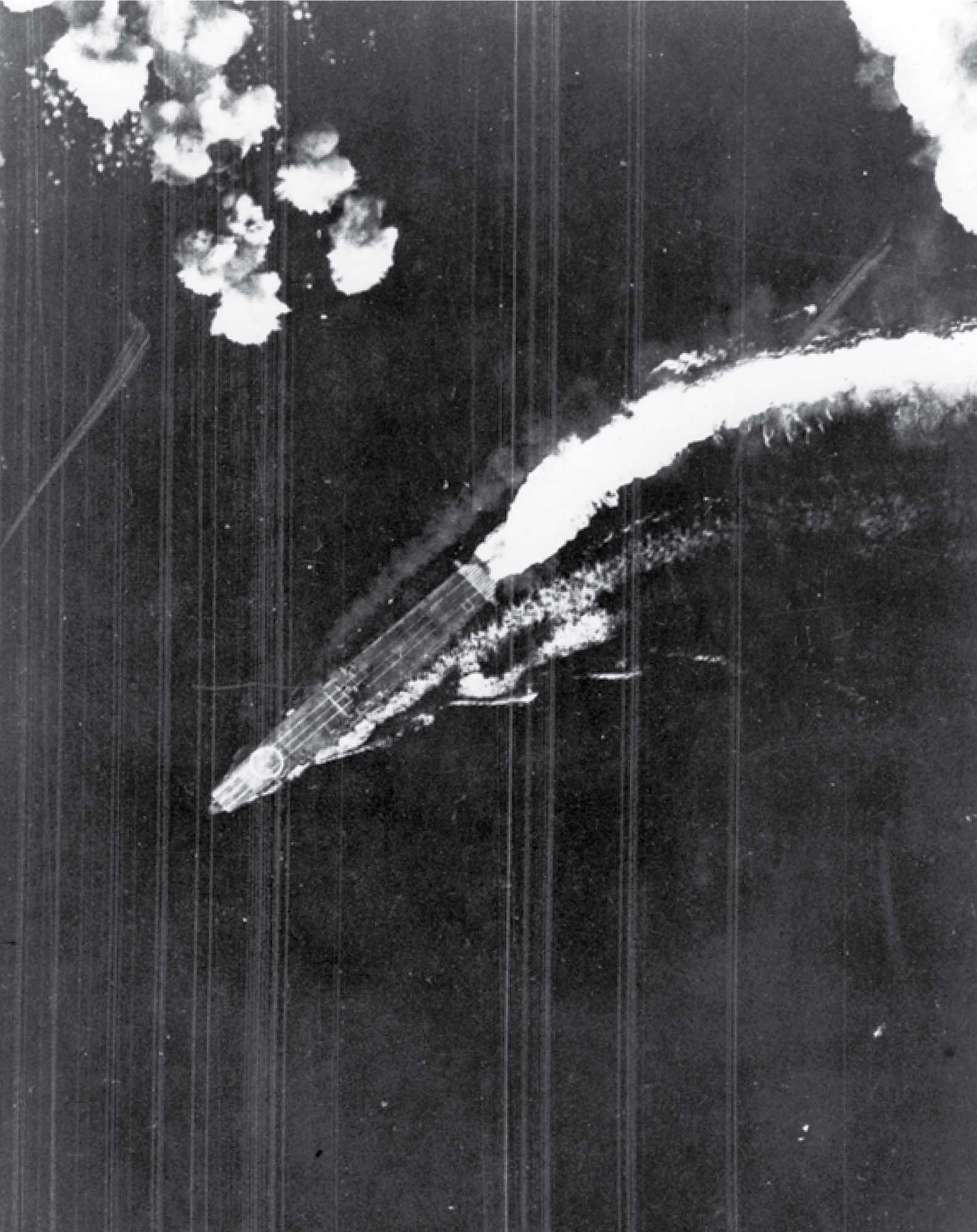 Photo shows an aircraft carrier moving downward through the sky.