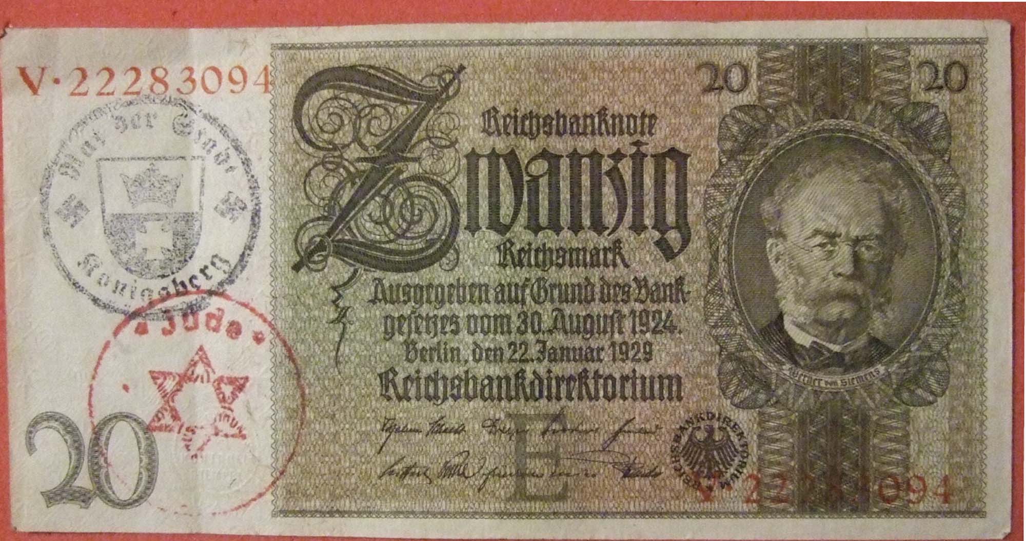 A photo of a German bank note with a red stamp of the star of David in the left hand corner.