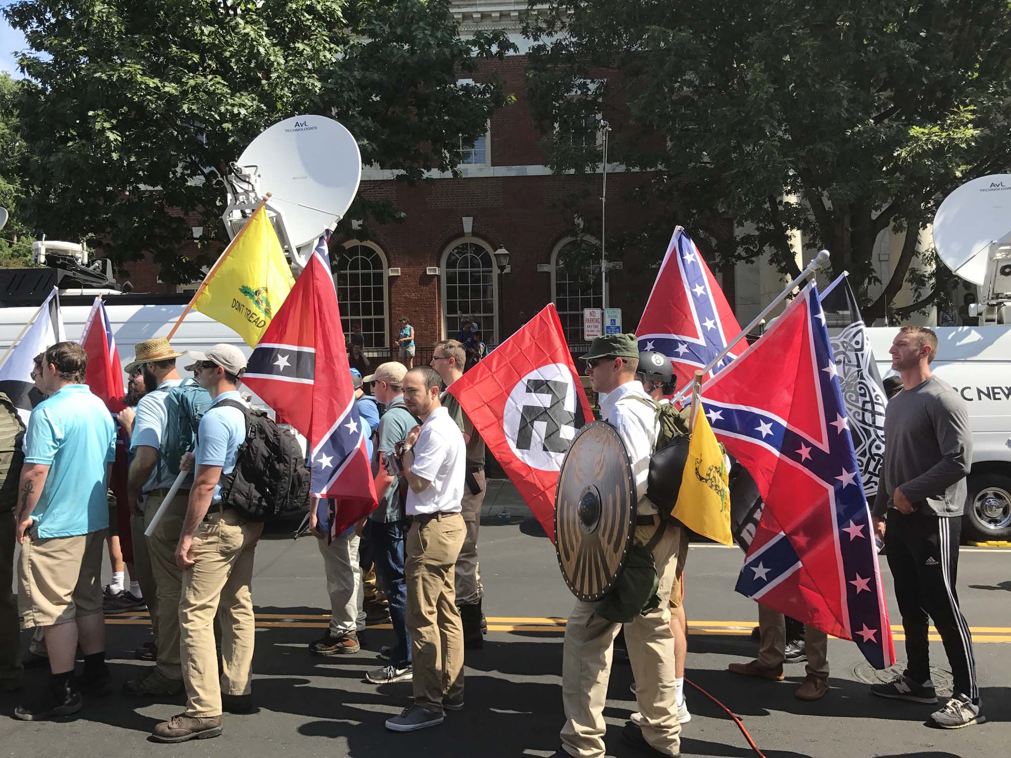 Photo of white nationalists bearing Confederate and Nazi flags on a street in Charlottesville, Virginia.