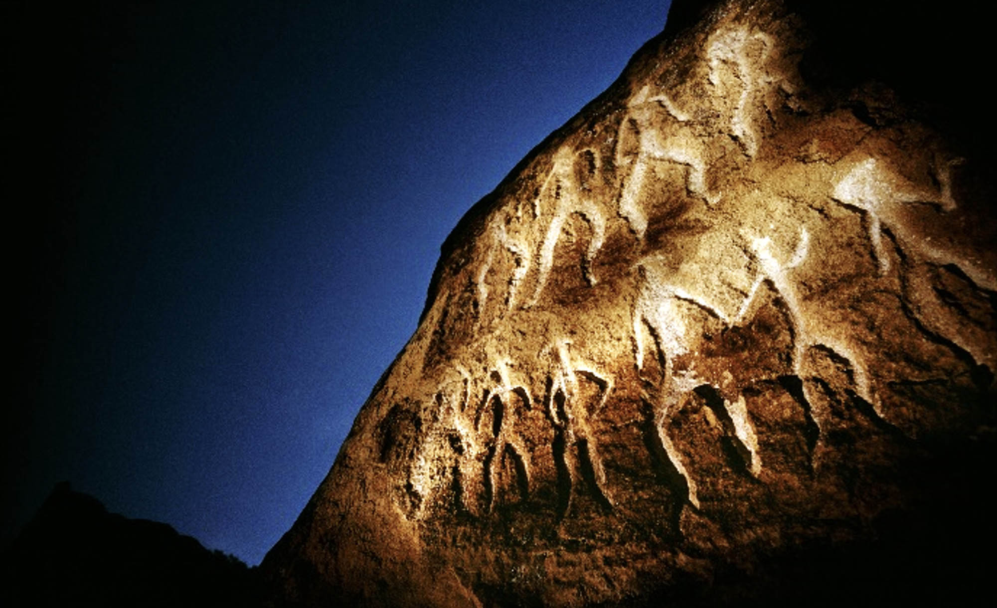 Rock carvings amongst a clear evening sky in the background in Azerbaijan.