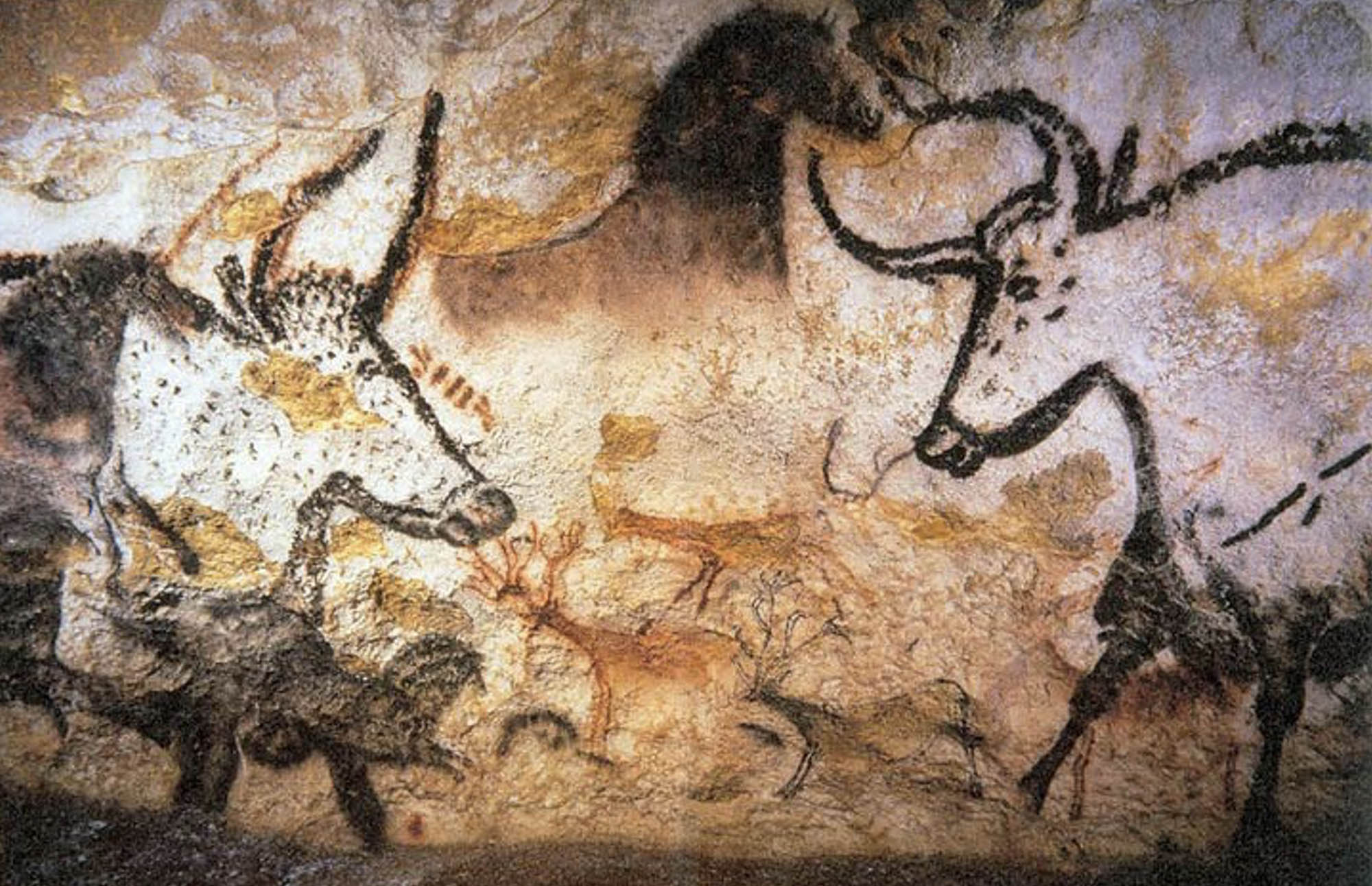 Close-up of a panel from a cave painting featuring aurochs, horses, and deer.