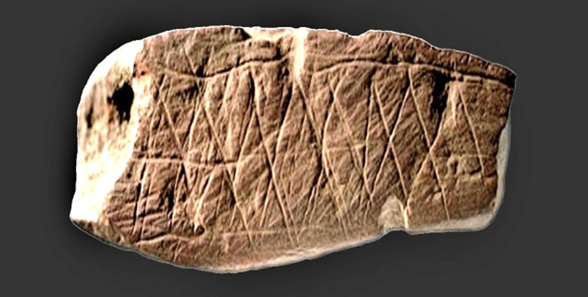 A stone with cross-hatched lines carved into it from the Blombos Cave.