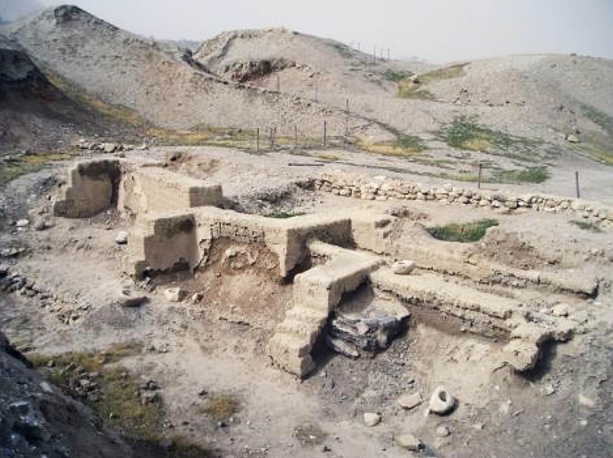Stone structures on dirt which are the remains of dwelling foundations in Jericho.