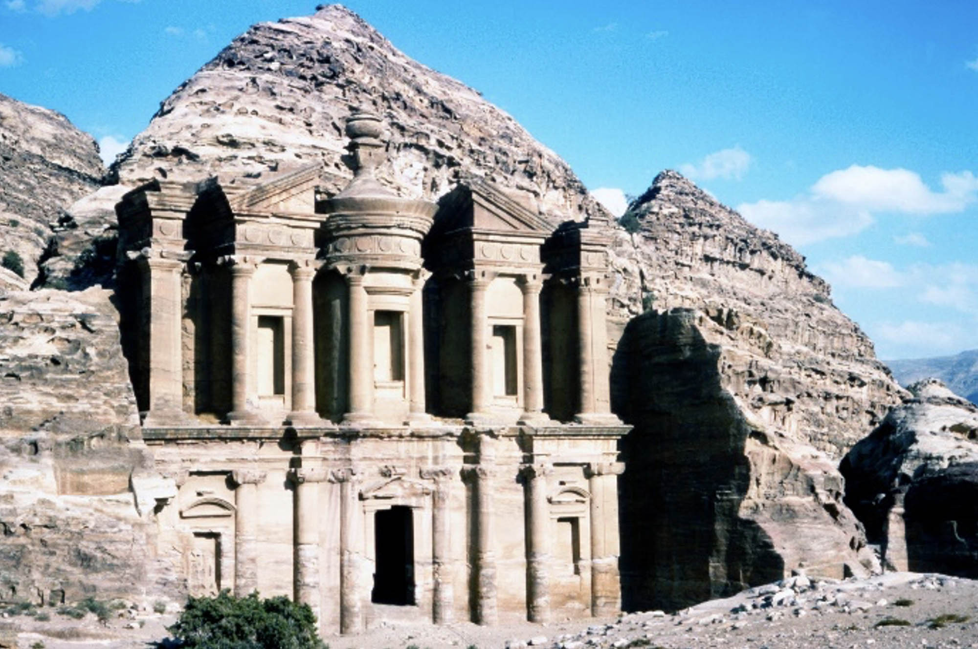 Photo of a monumental building carved out of rock with a blue sky in the background.