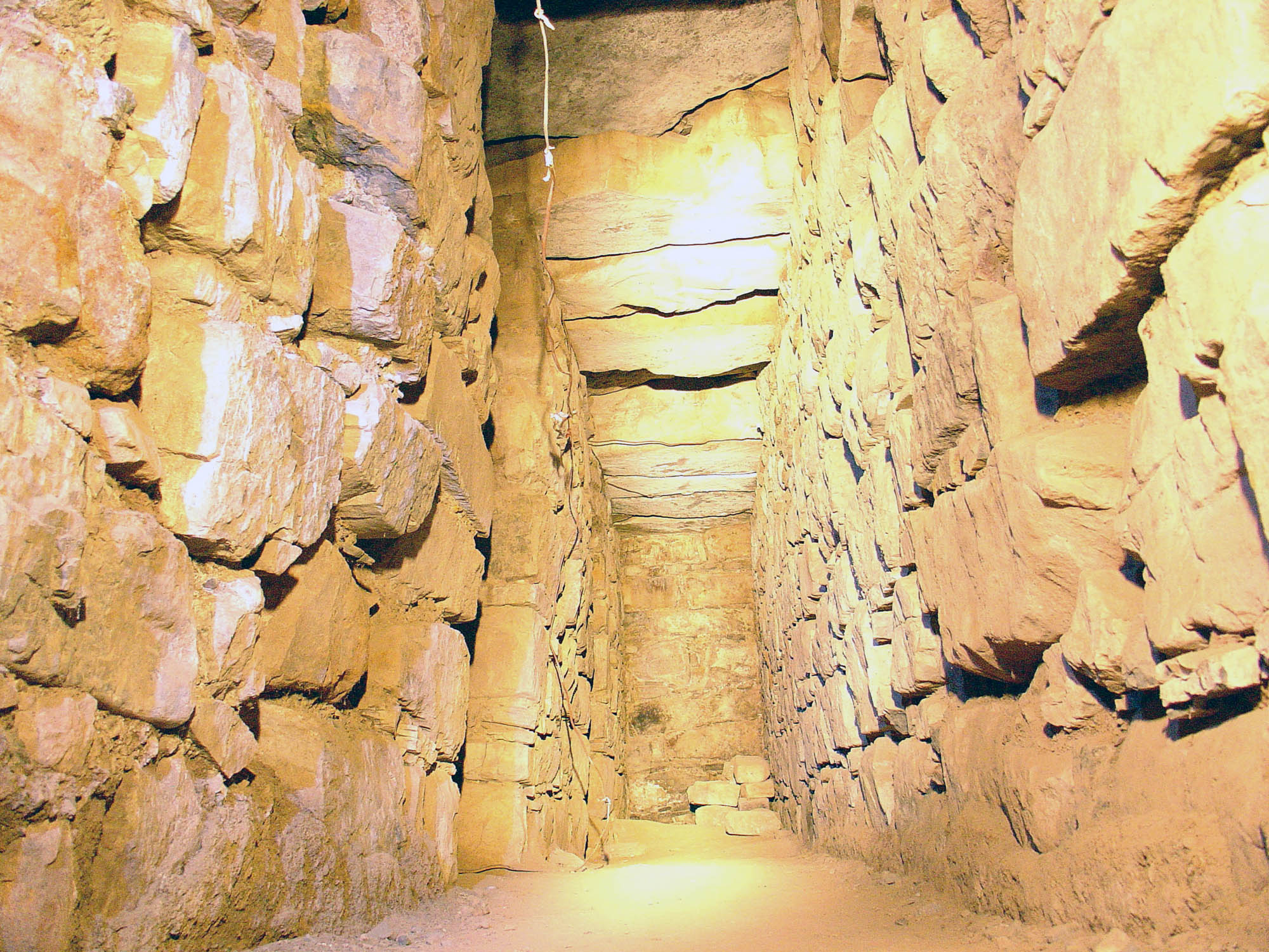 Hallway inside of a temple constructed from large stones.