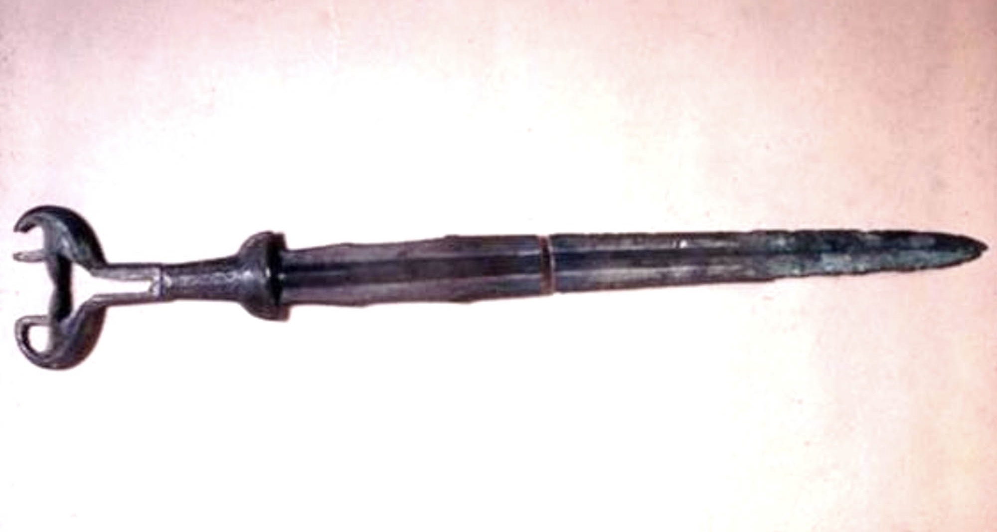 Ancient sword in a dark metal, broken in half, with a large, shield shaped pommel.