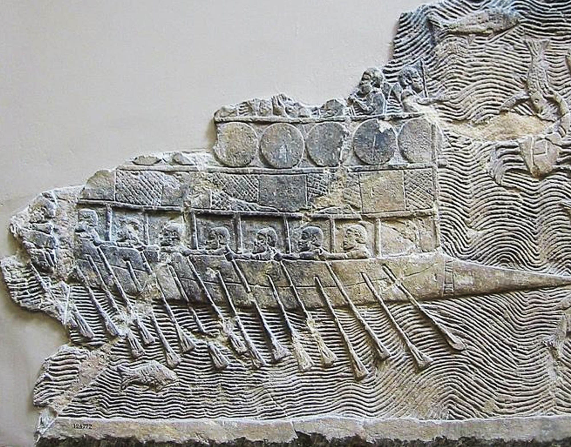 Carved stone relief of a warship with two rows of oars.