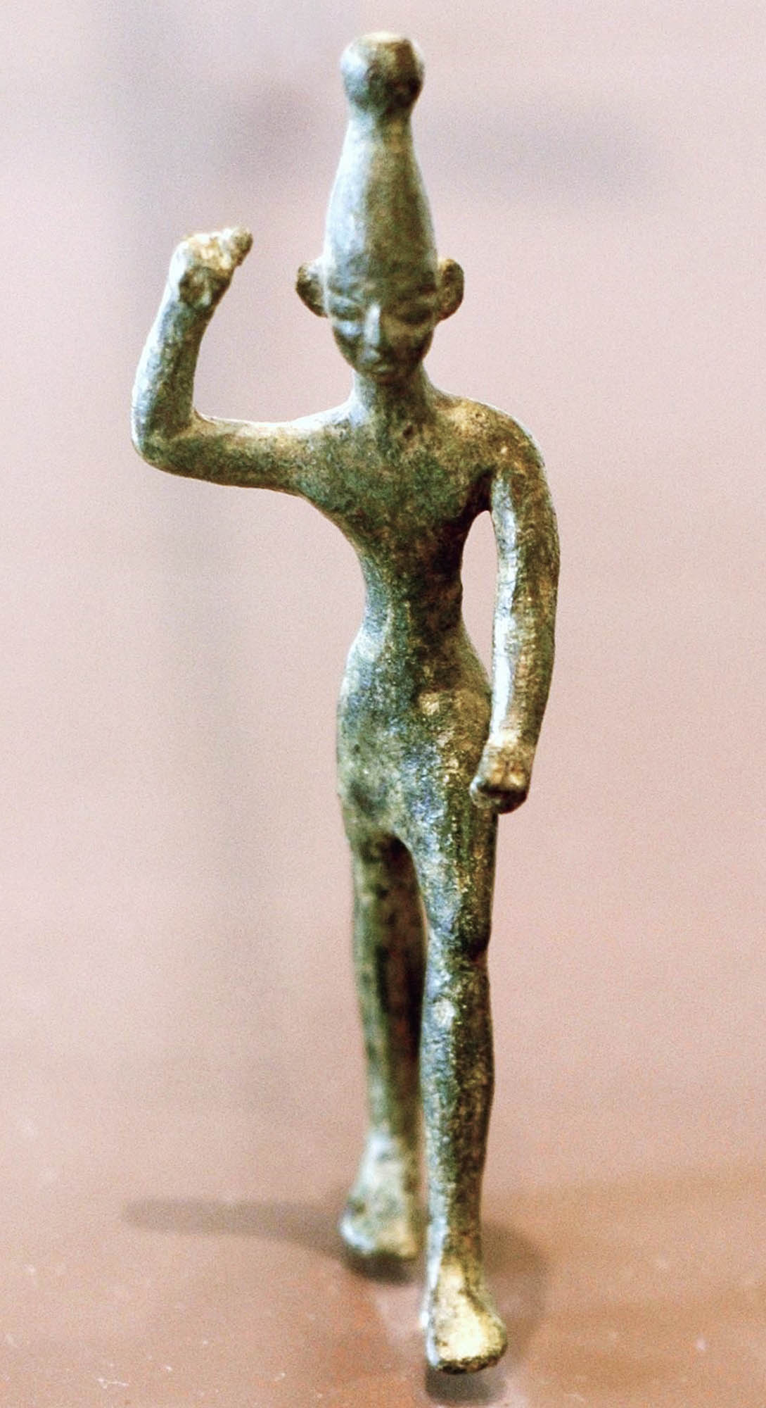 Stone figure of a warrior with a raised arm, as if throwing a spear.