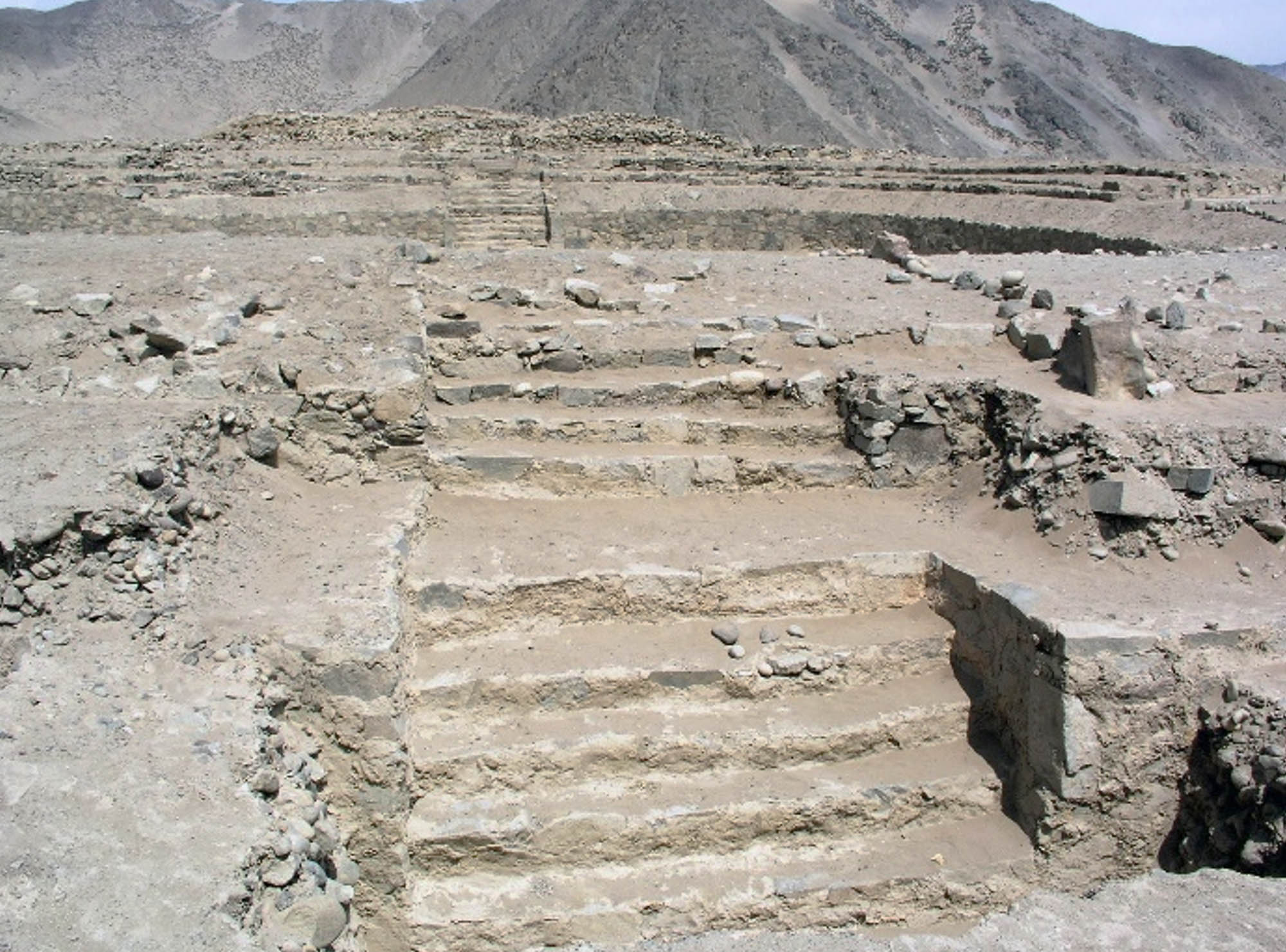Photograph shows the remains of a staircase and a structure carved into rock.