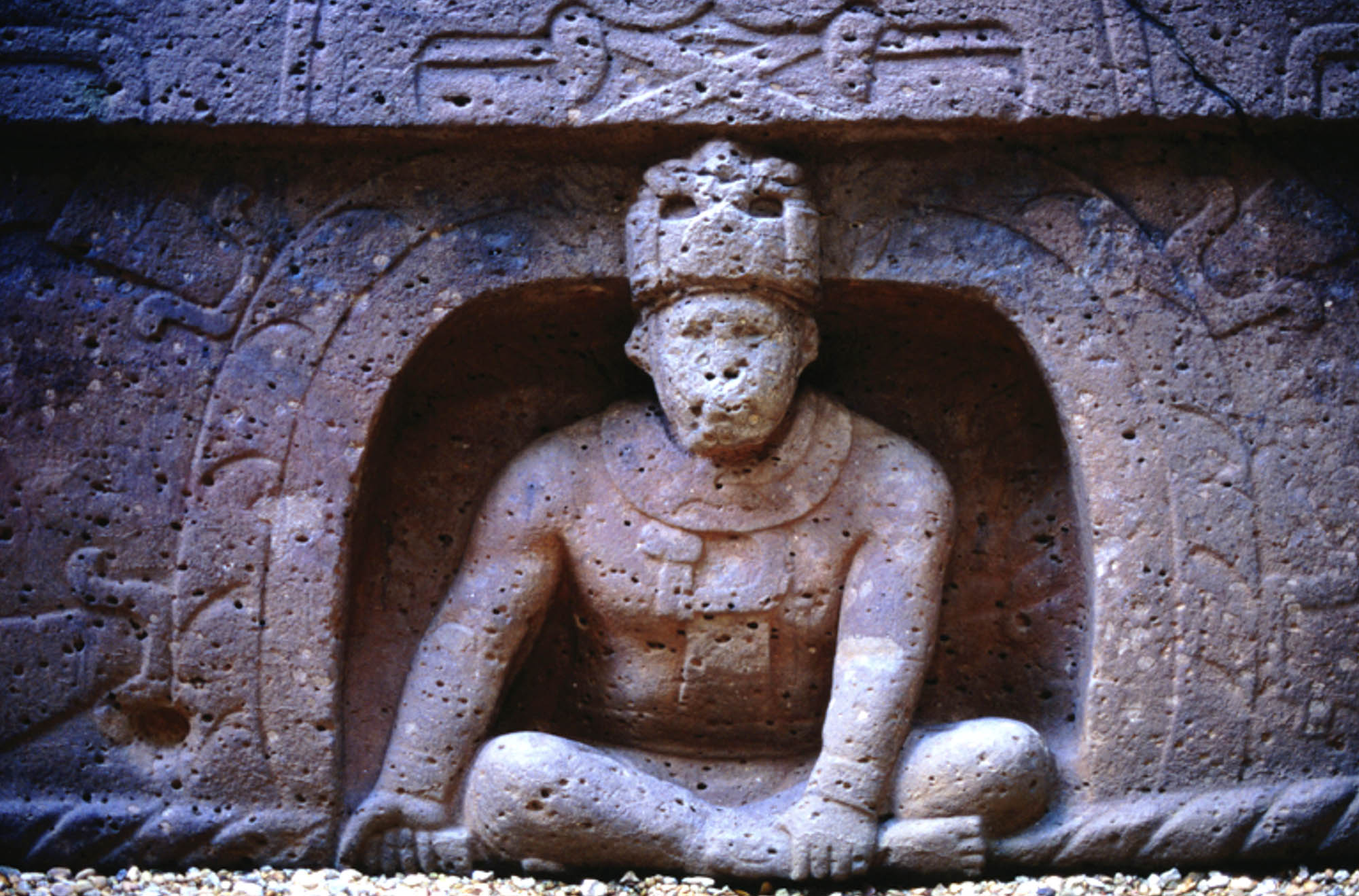 Detailed stone carving of a person sitting cross-legged in a dome