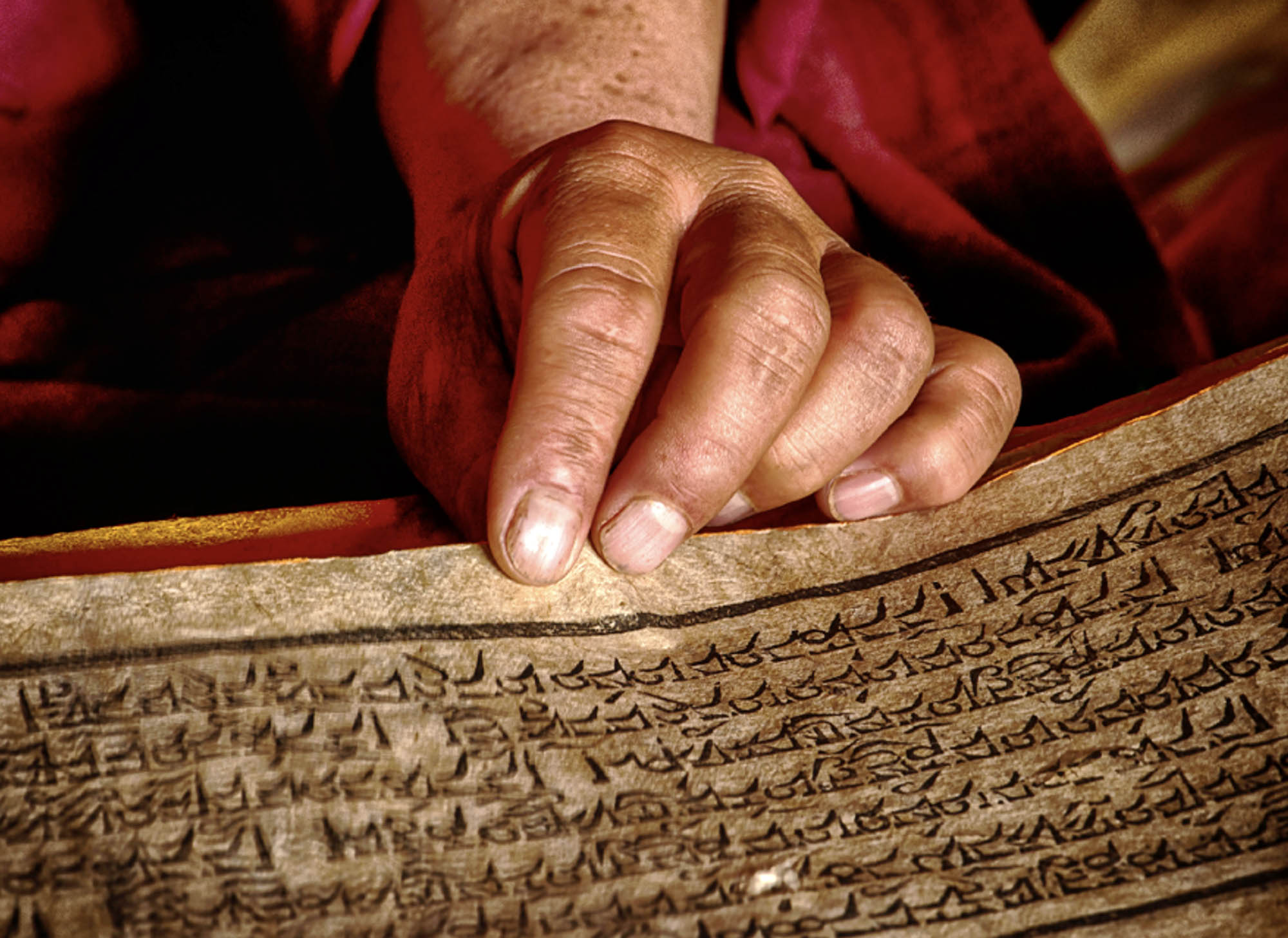Close up image of a person’s hand holding a panel with written symbols on it